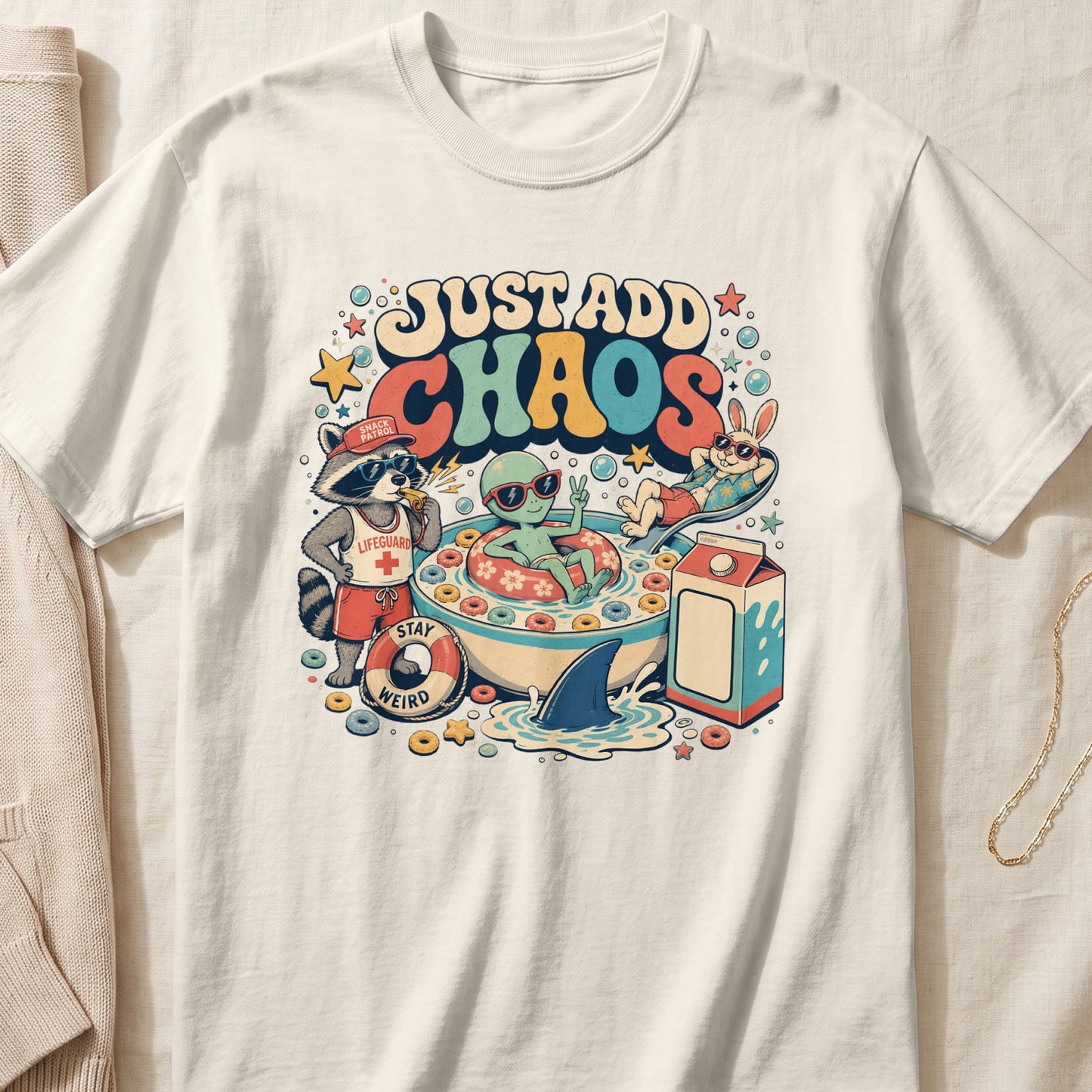 An off-white t-shirt featuring a retro graphic of an alien and animals in a cereal bowl.