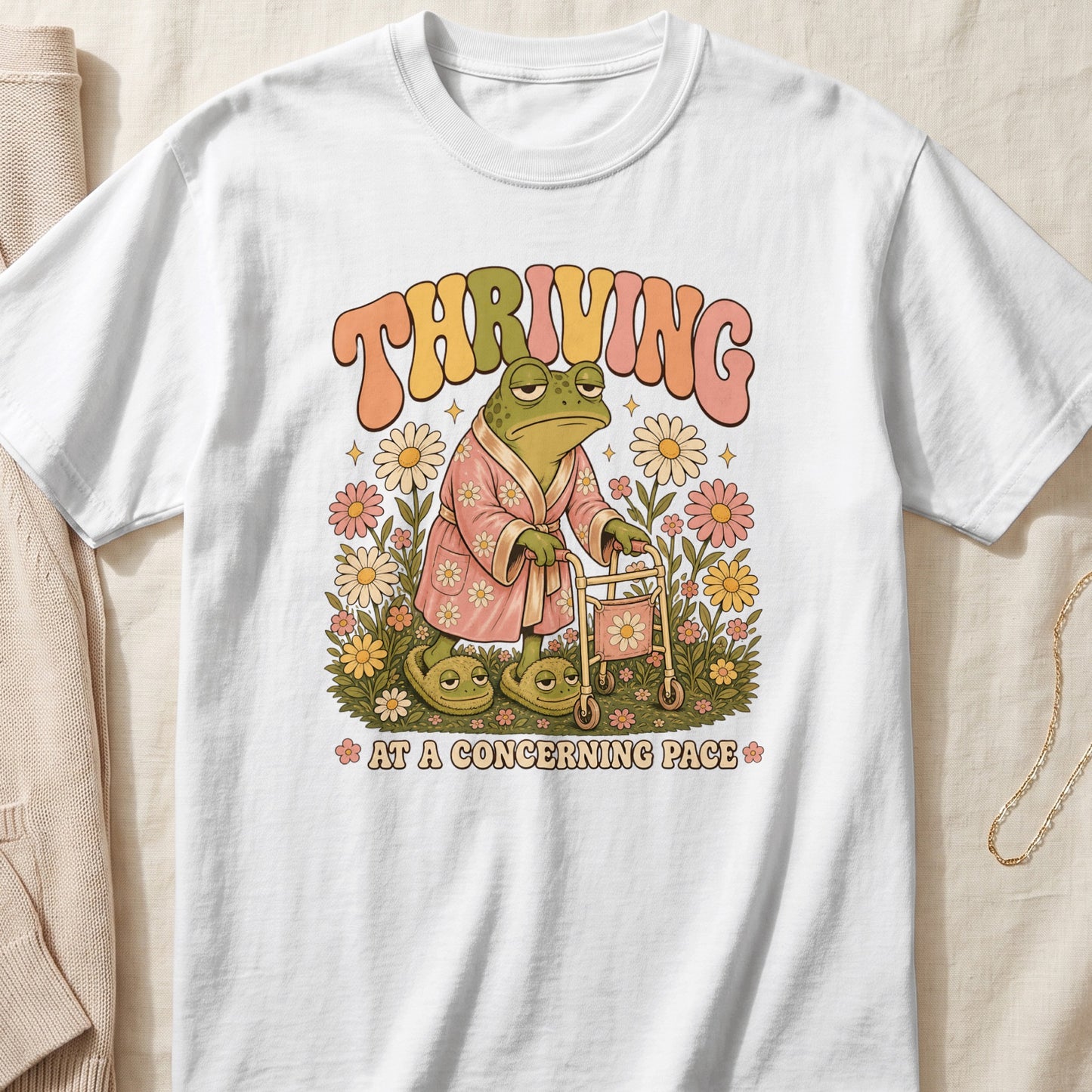 Frog in bathrobe and slippers with walker, text "THRIVING AT A CONCERNING PACE".
