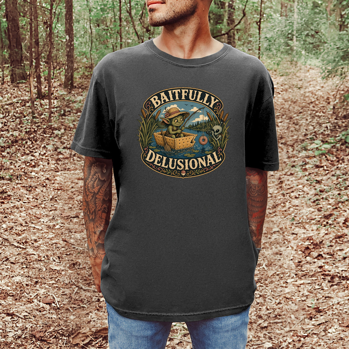 T-shirt graphic with "Baitfully Delusional" text featuring a goblin fishing from a cracker boat.
