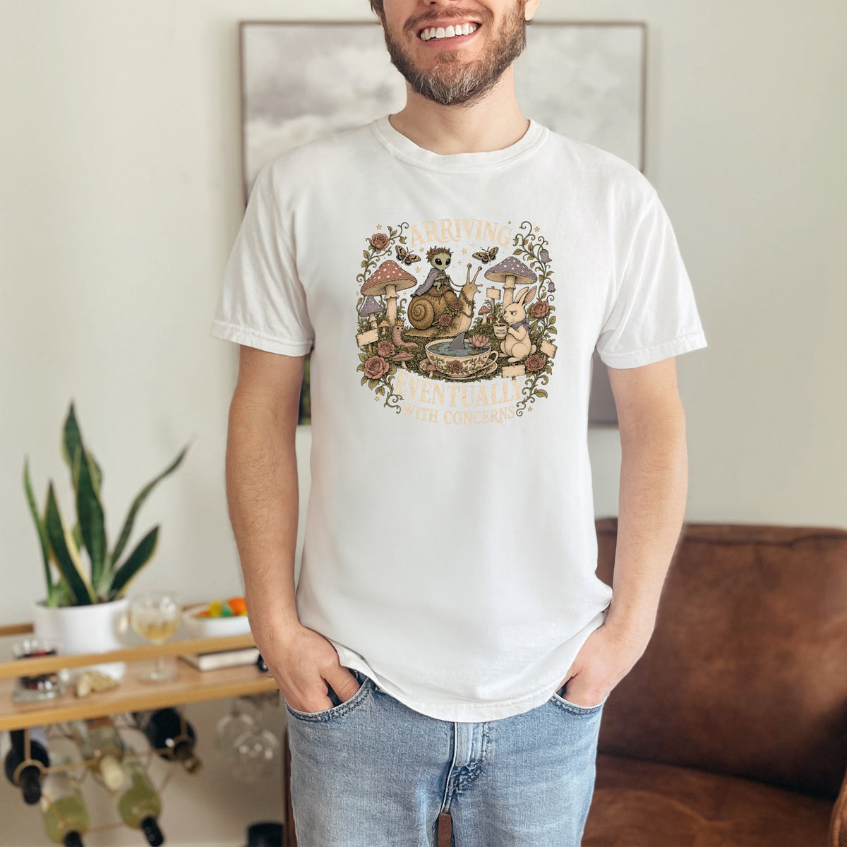 T-shirt with mushroom, snail, and bunny graphic and text "ARRIVING EVENTUALLY WITH CONCERNS".