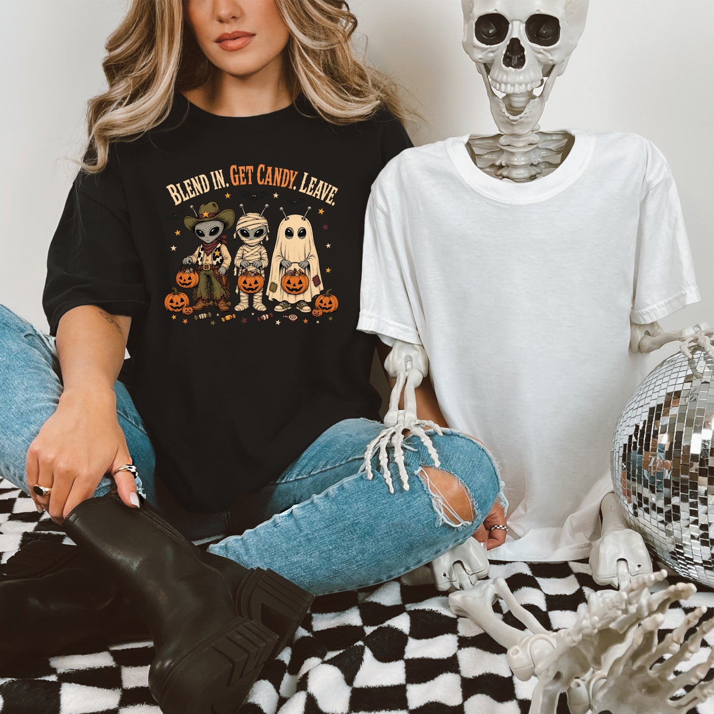 T-shirt with alien, mummy, ghost, and pumpkins wearing cowboy hats. Text reads "Blend In. Get Candy. Leave."