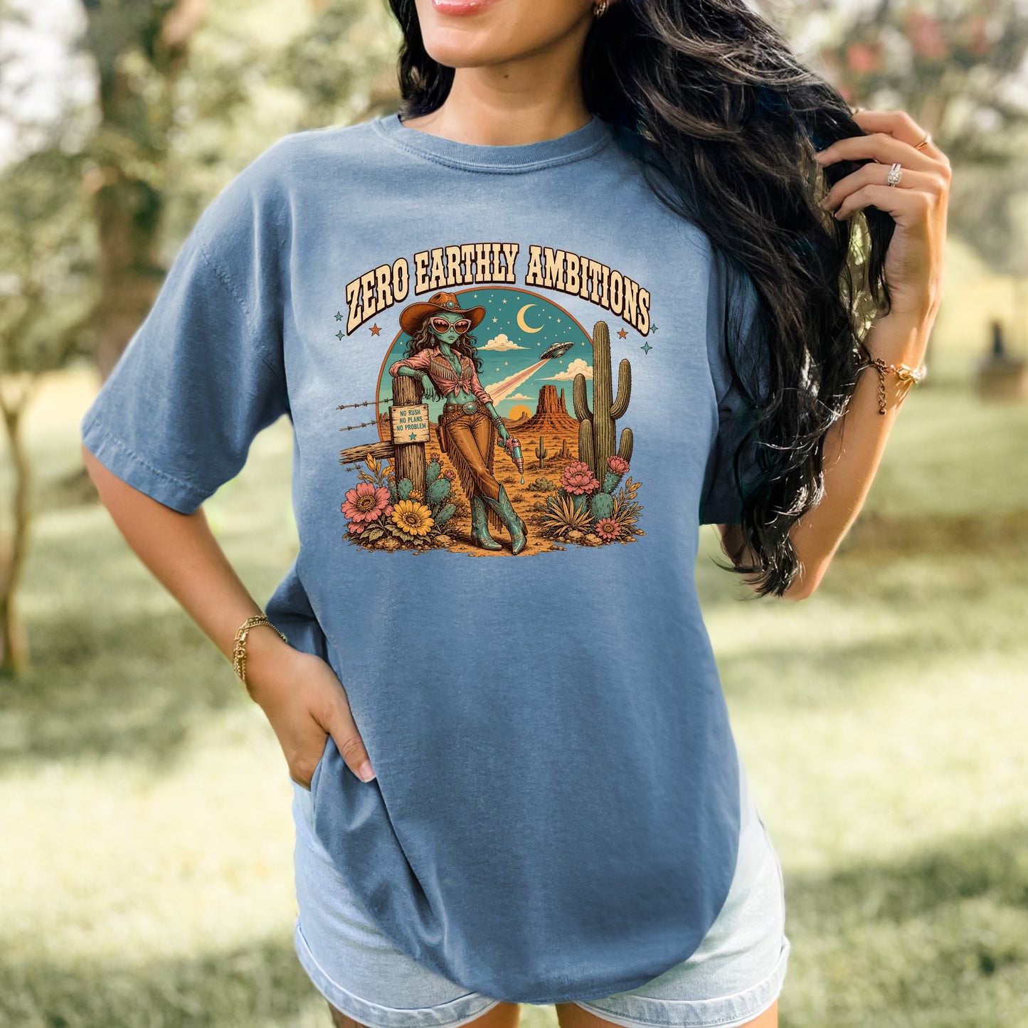 Graphic with "Zero Earthly Ambitions" text and desert scene featuring an alien cowgirl.