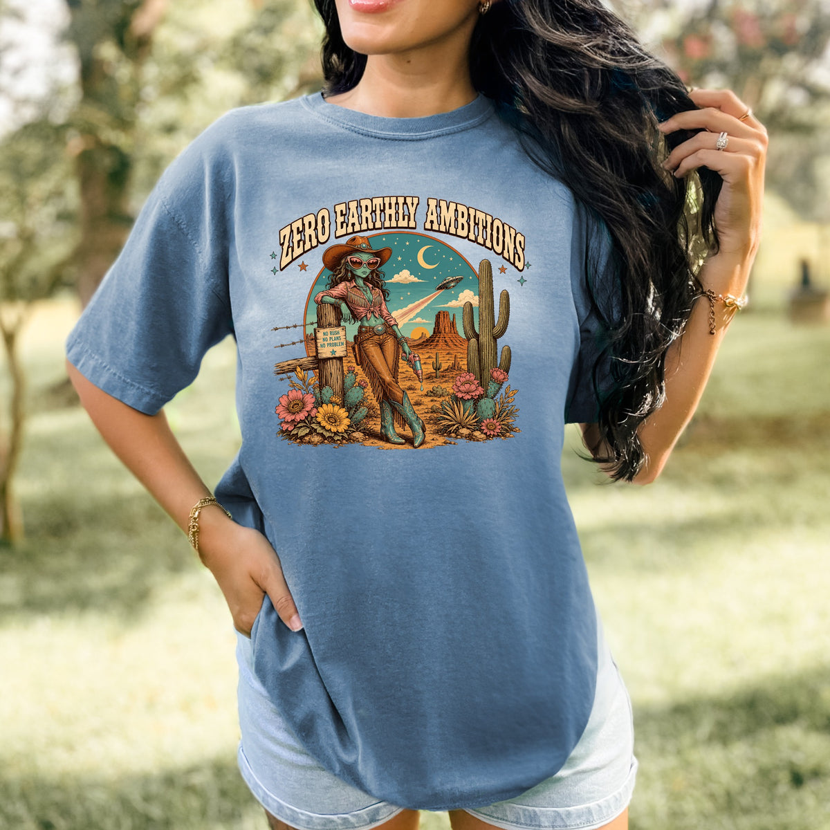 Graphic with "Zero Earthly Ambitions" text and desert scene featuring an alien cowgirl.