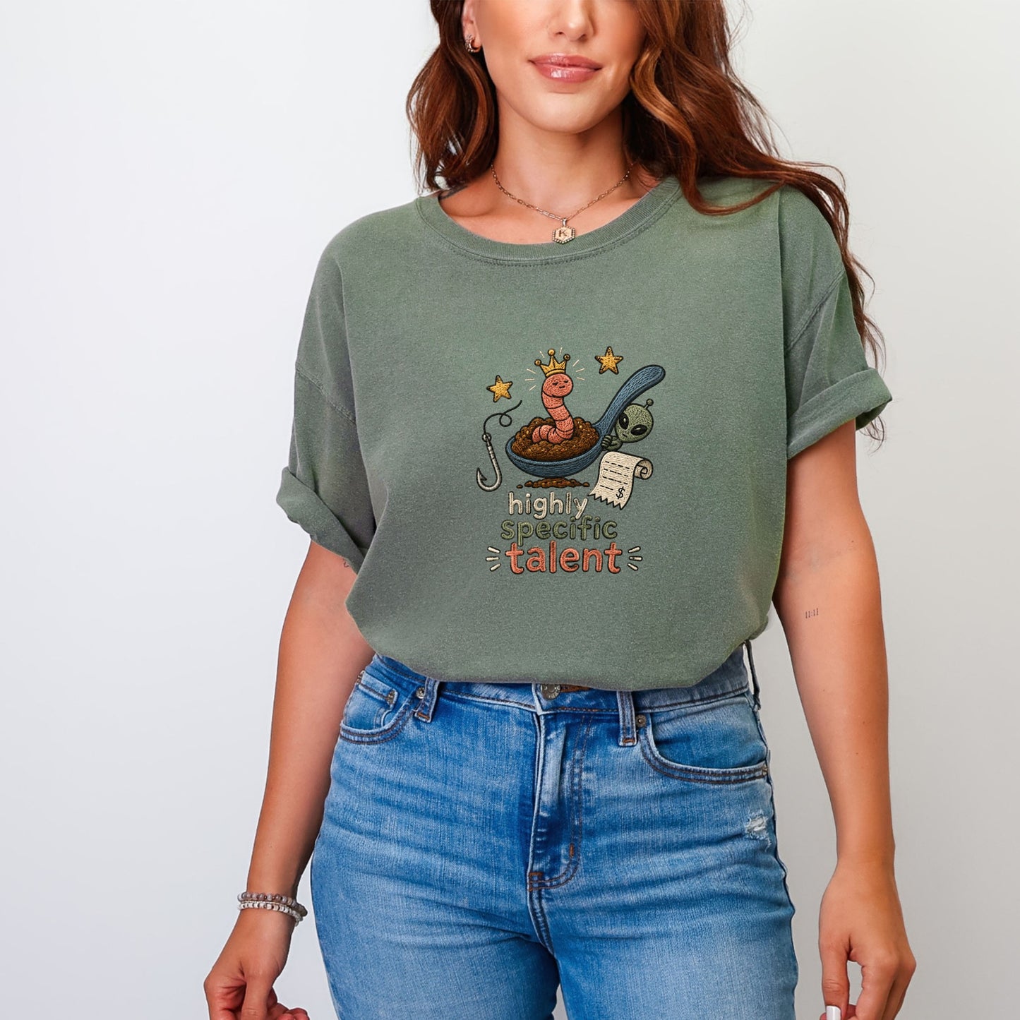T-shirt graphic of a worm with a crown, spoon, alien, and text "highly specific talent".