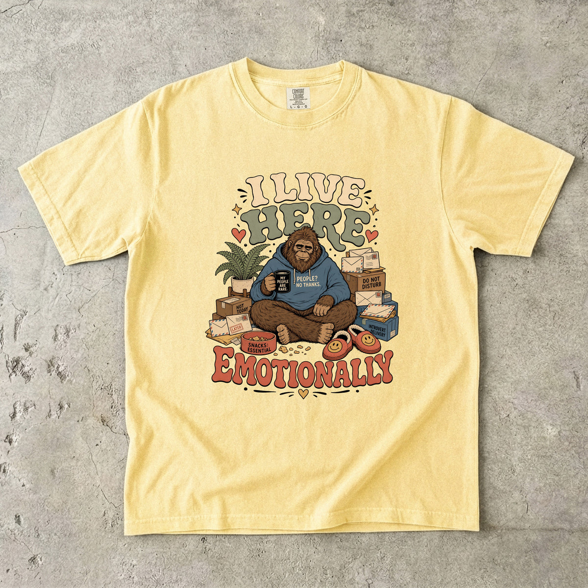 Yellow t-shirt with Bigfoot graphic "I LIVE HERE EMOTIONALLY" and text.