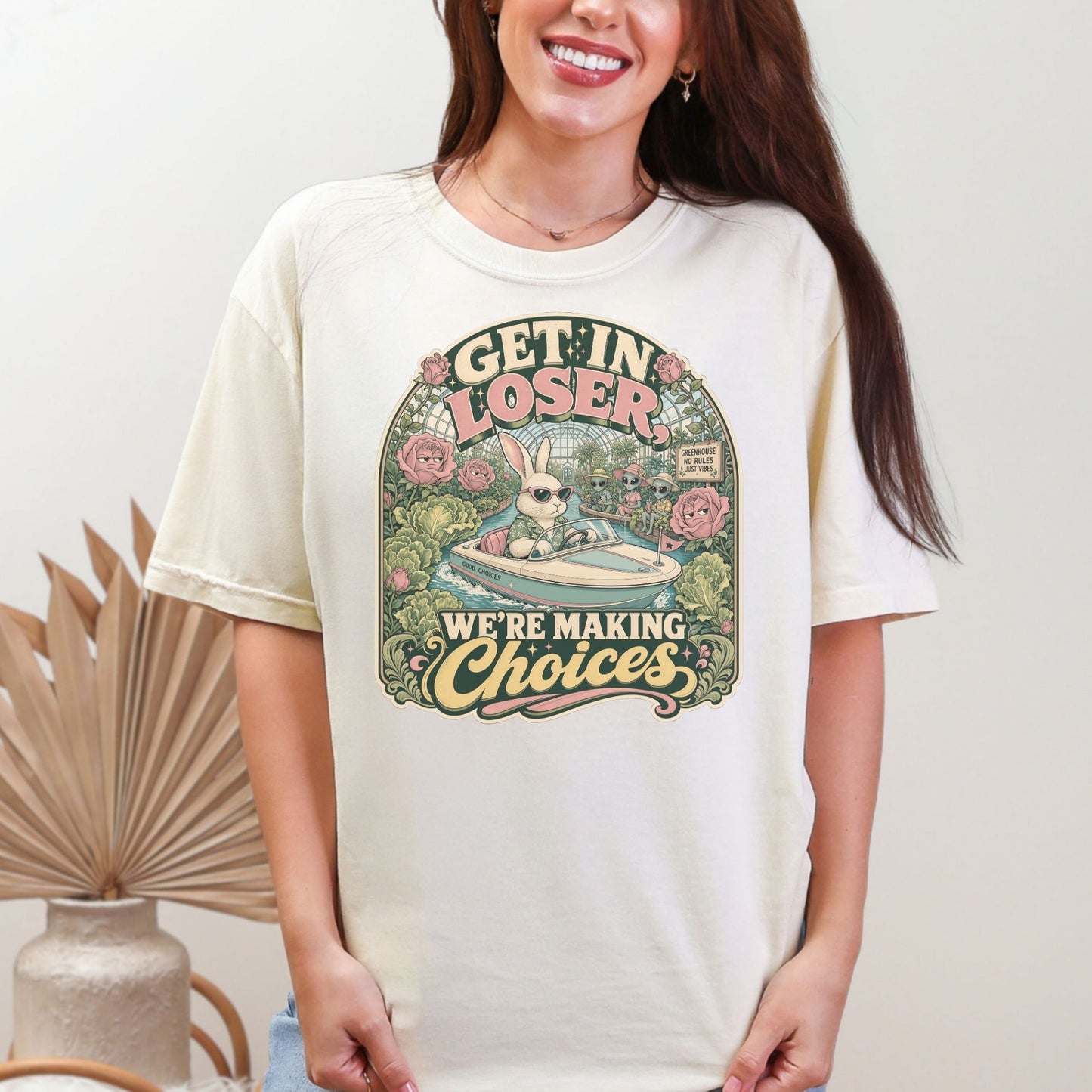 T-shirt graphic: bunny in sunglasses driving a boat with aliens, text "GET IN LOSER WE'RE MAKING CHOICES".