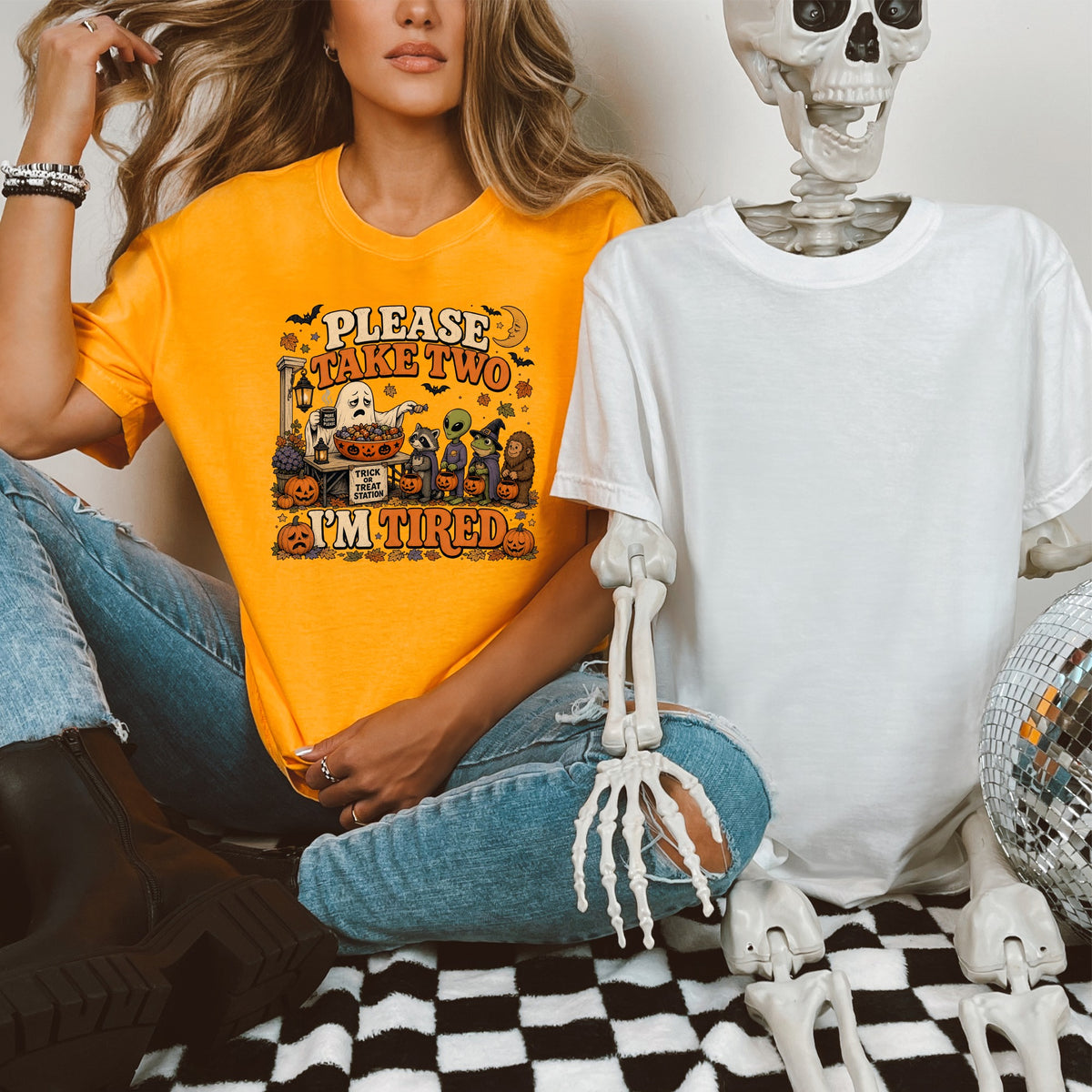 Orange t-shirt with "PLEASE TAKE TWO I'M TIRED" Halloween graphic and various creatures.