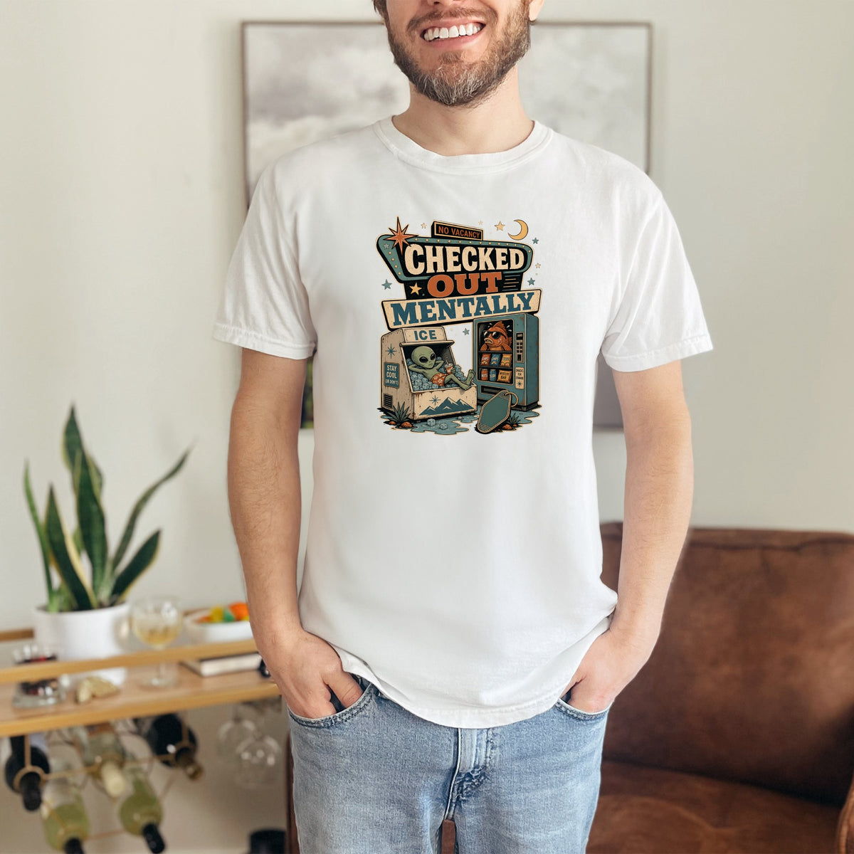 White t-shirt with "Checked Out Mentally" graphic featuring an alien and fish.