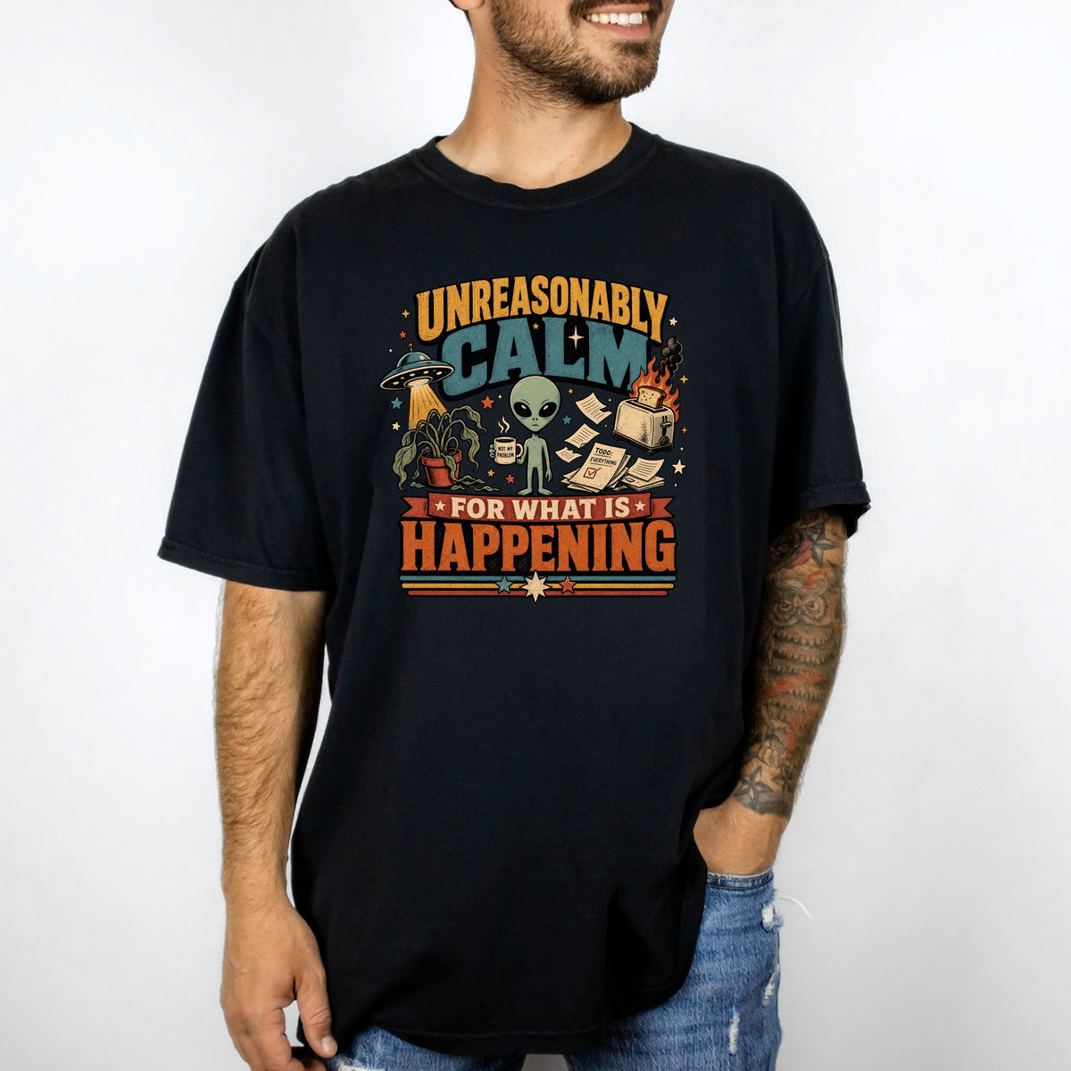 Black t-shirt graphic with text "Unreasonably Calm For What Is Happening" and alien imagery.