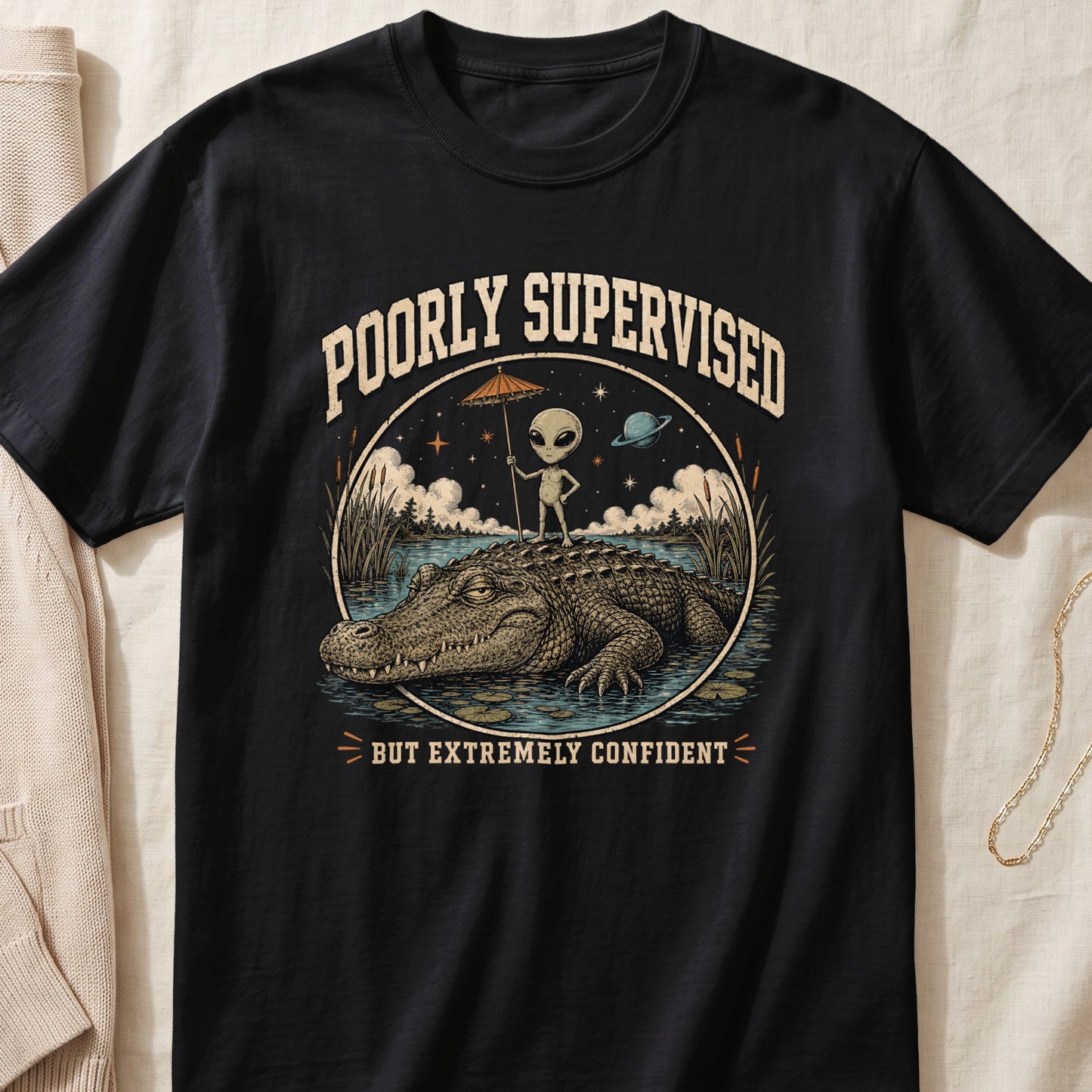 Alien with umbrella standing on alligator, text "POORLY SUPERVISED BUT EXTREMELY CONFIDENT."