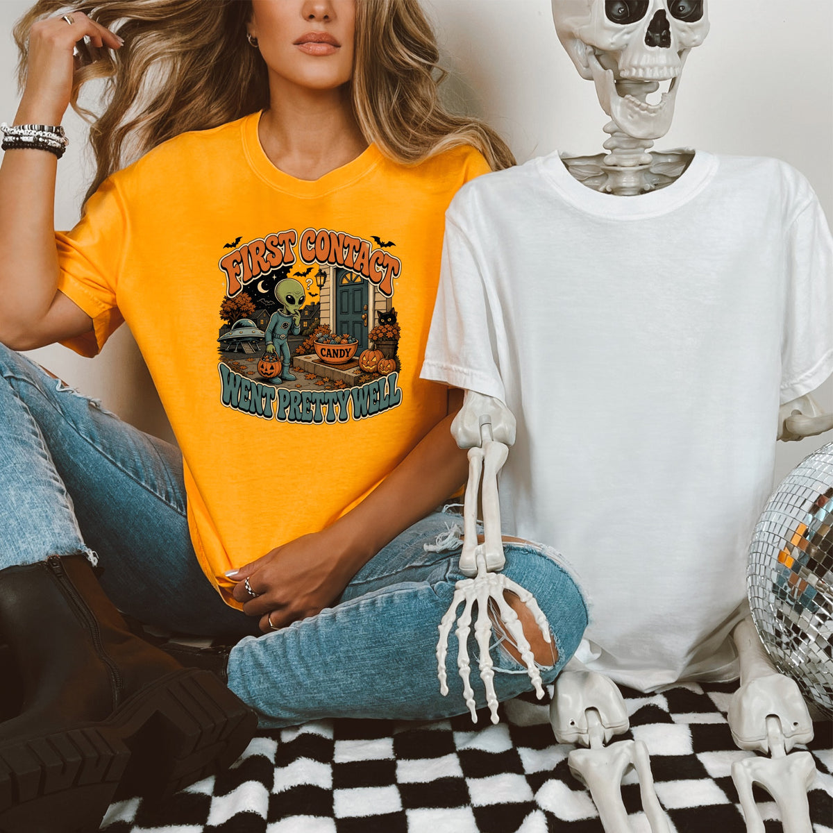 Orange t-shirt with "First Contact Went Pretty Well" and alien Halloween graphic.