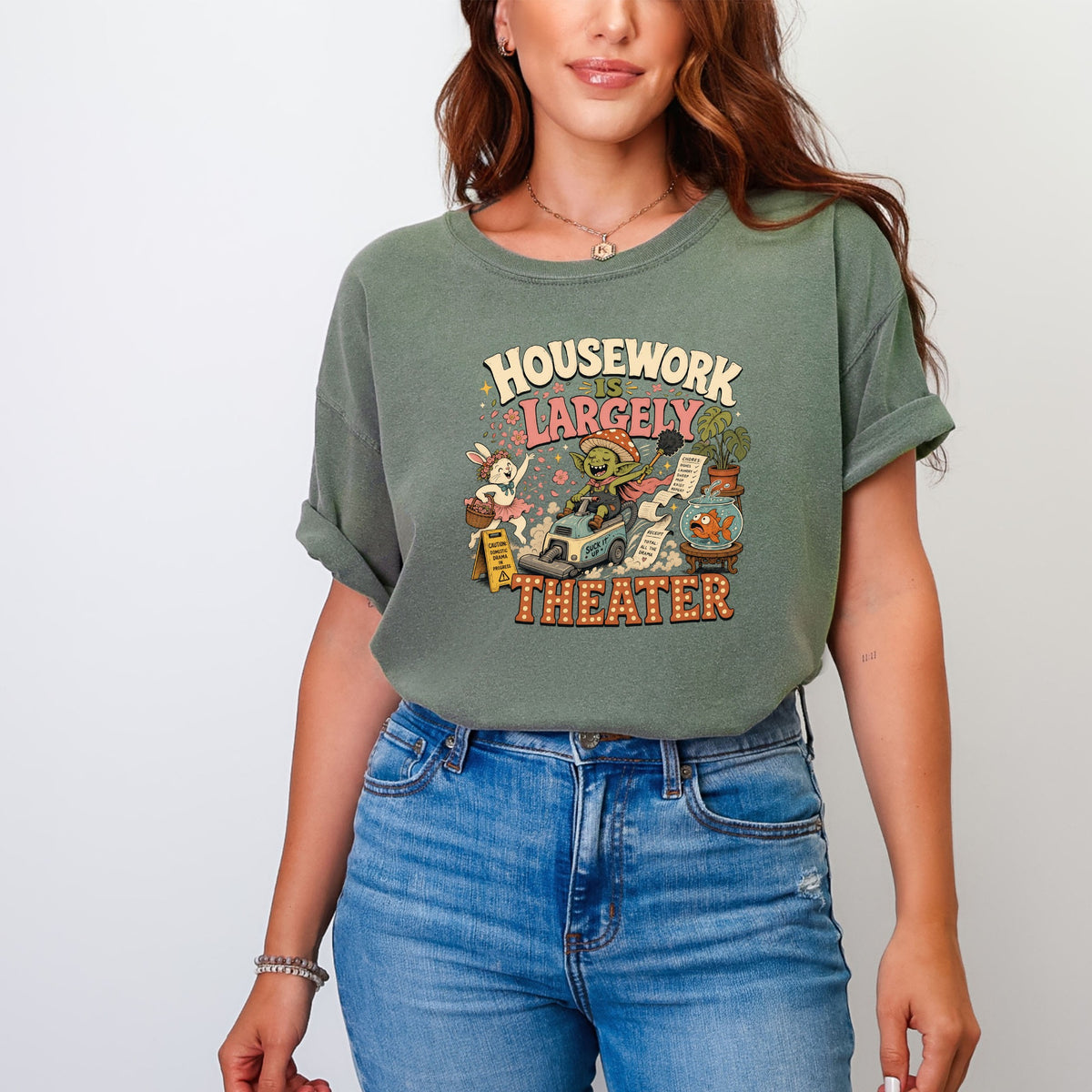 Green t-shirt with "Housework is Largely Theater" graphic of a goblin riding a vacuum.