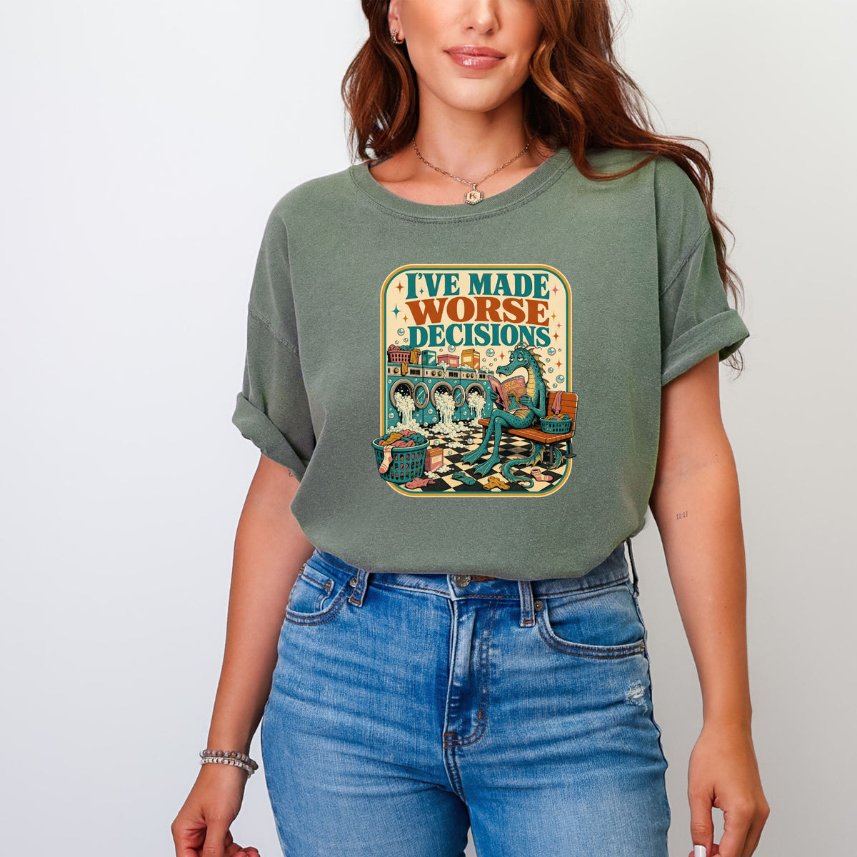 Green t-shirt with graphic that reads "I've made worse decisions" showing a dragon reading.
