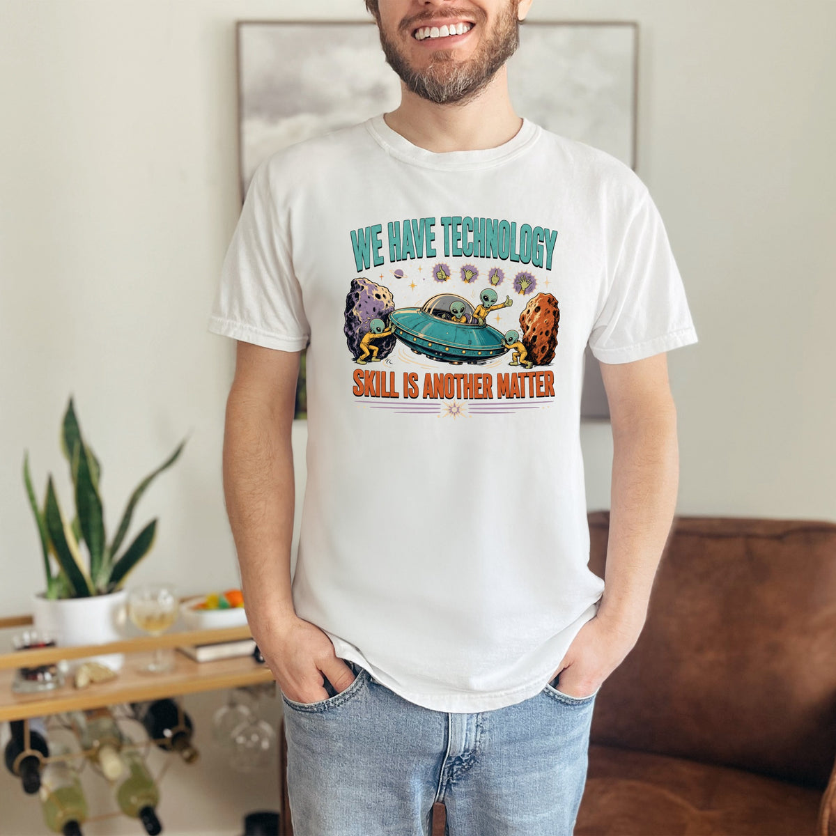 White t-shirt with aliens and UFO graphic and text "WE HAVE TECHNOLOGY SKILL IS ANOTHER MATTER".