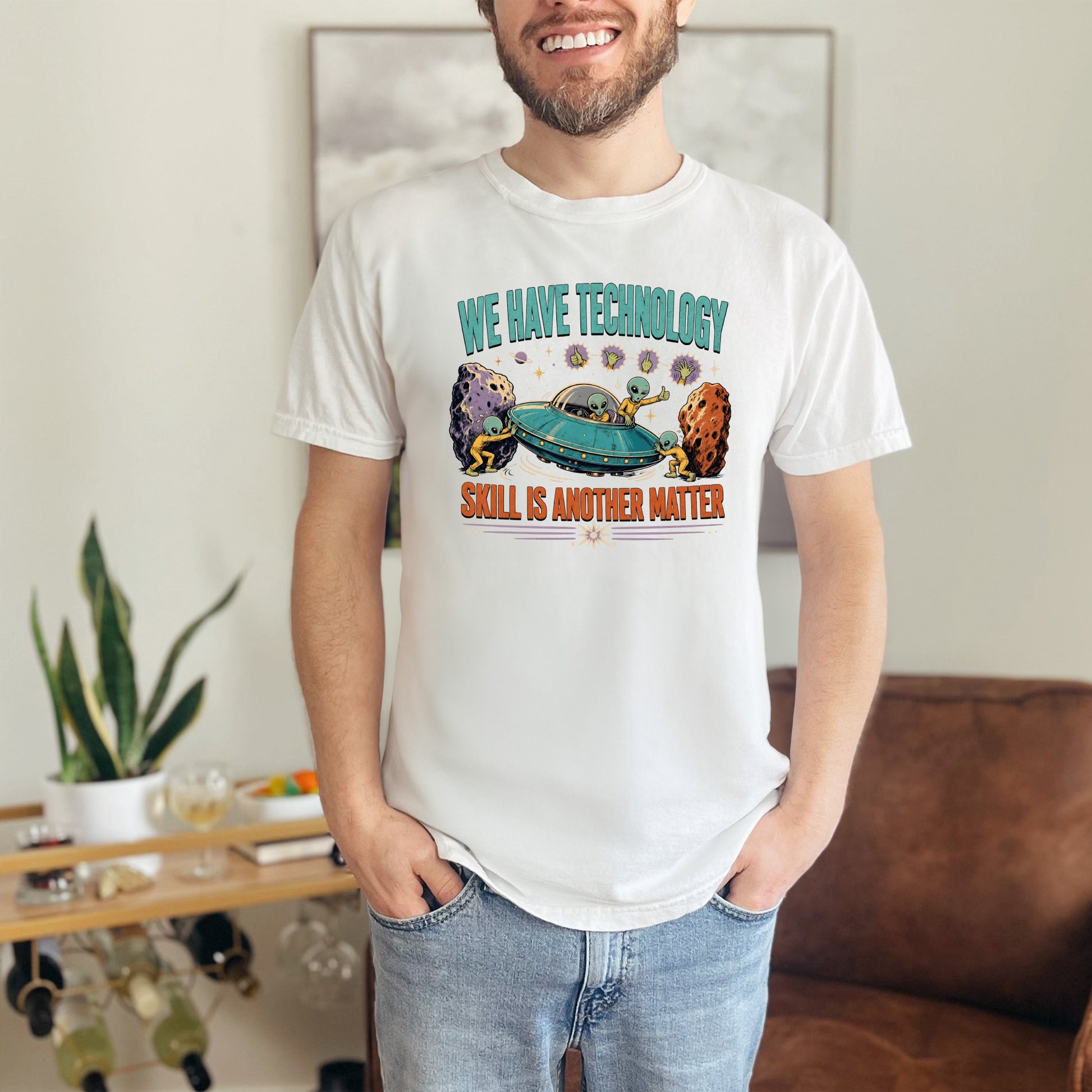 White t-shirt with aliens and UFO graphic and text "WE HAVE TECHNOLOGY SKILL IS ANOTHER MATTER".