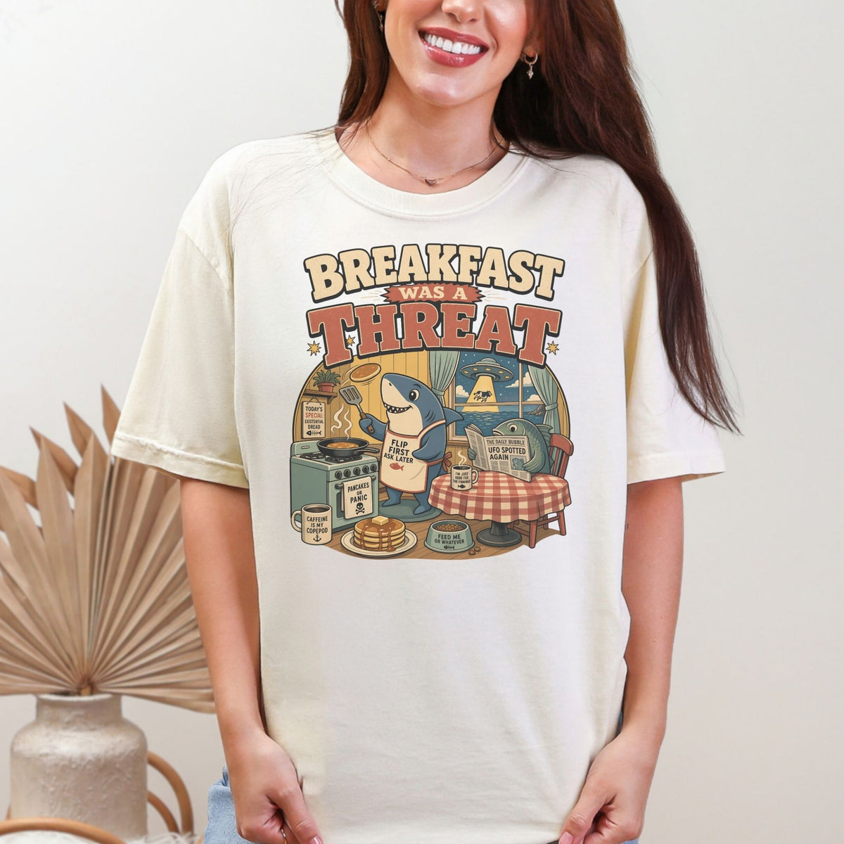 Shark making pancakes with text "Breakfast Was A Threat" and UFOs in background.
