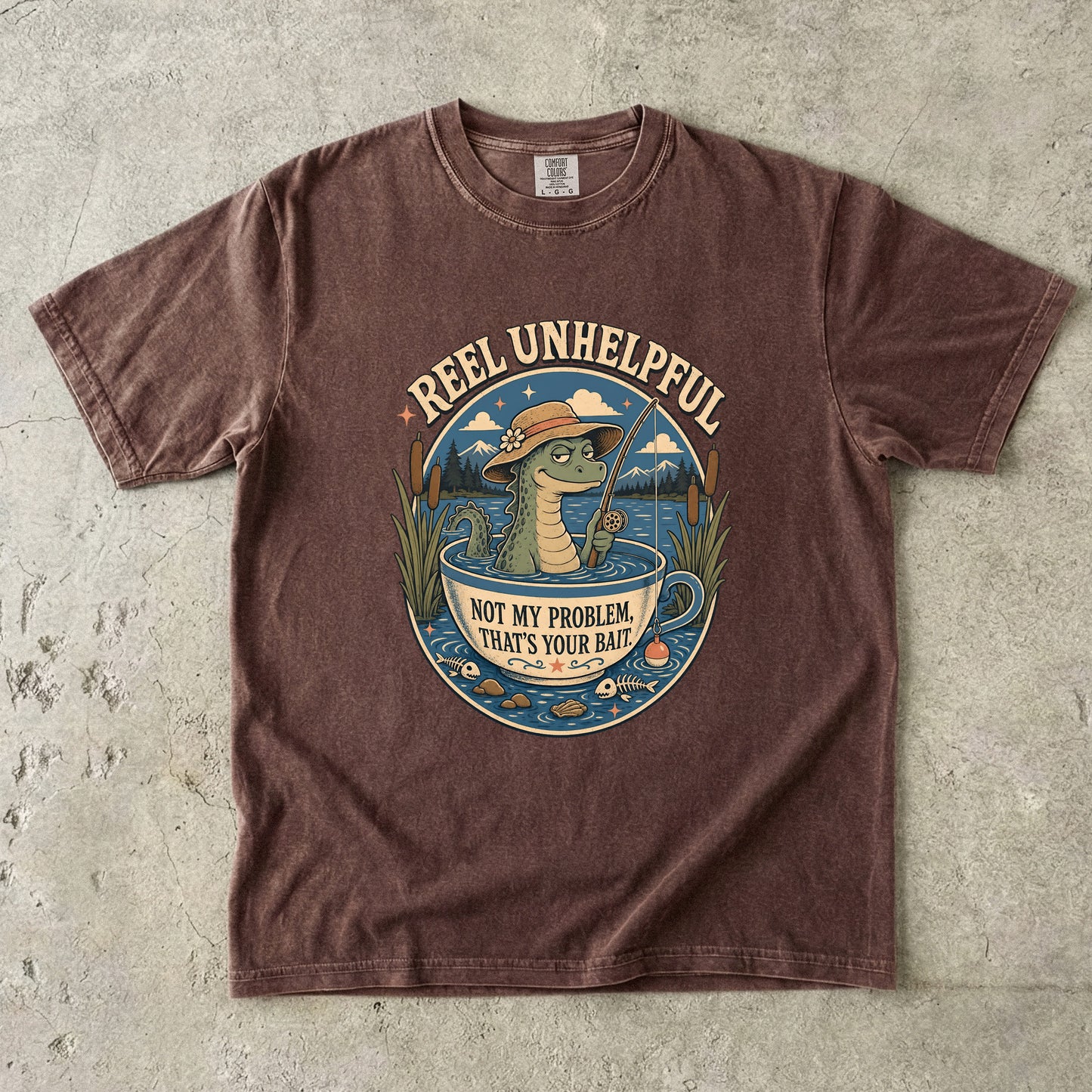 T-shirt graphic of a crocodile fishing in a teacup with text "Reel Unhelpful."