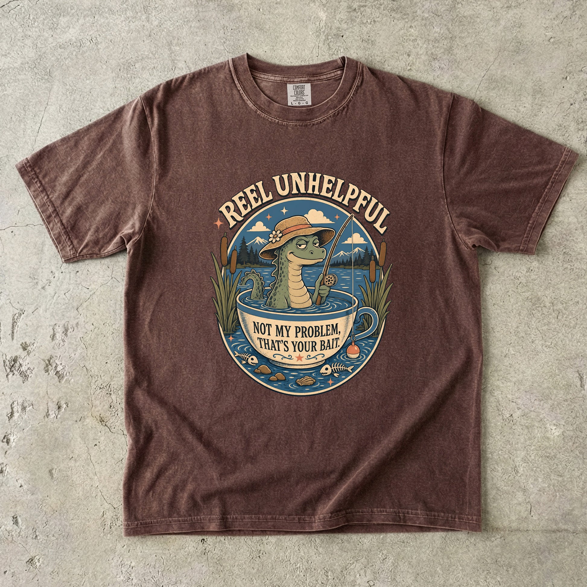 T-shirt graphic of a crocodile fishing in a teacup with text "Reel Unhelpful."