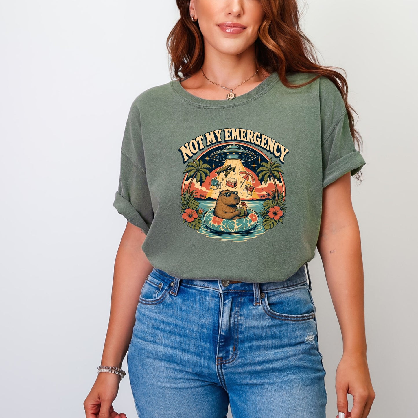T-shirt with graphic of capybara on float with UFO and text "NOT MY EMERGENCY."