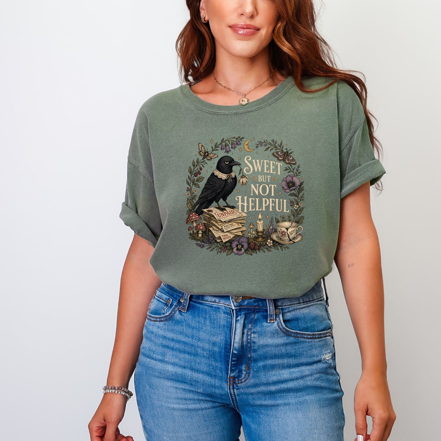 Green t-shirt with a crow perched on unpaid bills, reading "Sweet But Not Helpful".