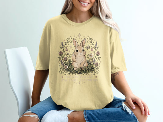 Yellow t-shirt with rabbit, flowers, and text "EMOTIONALLY AVAILABLE ELSEWHERE".