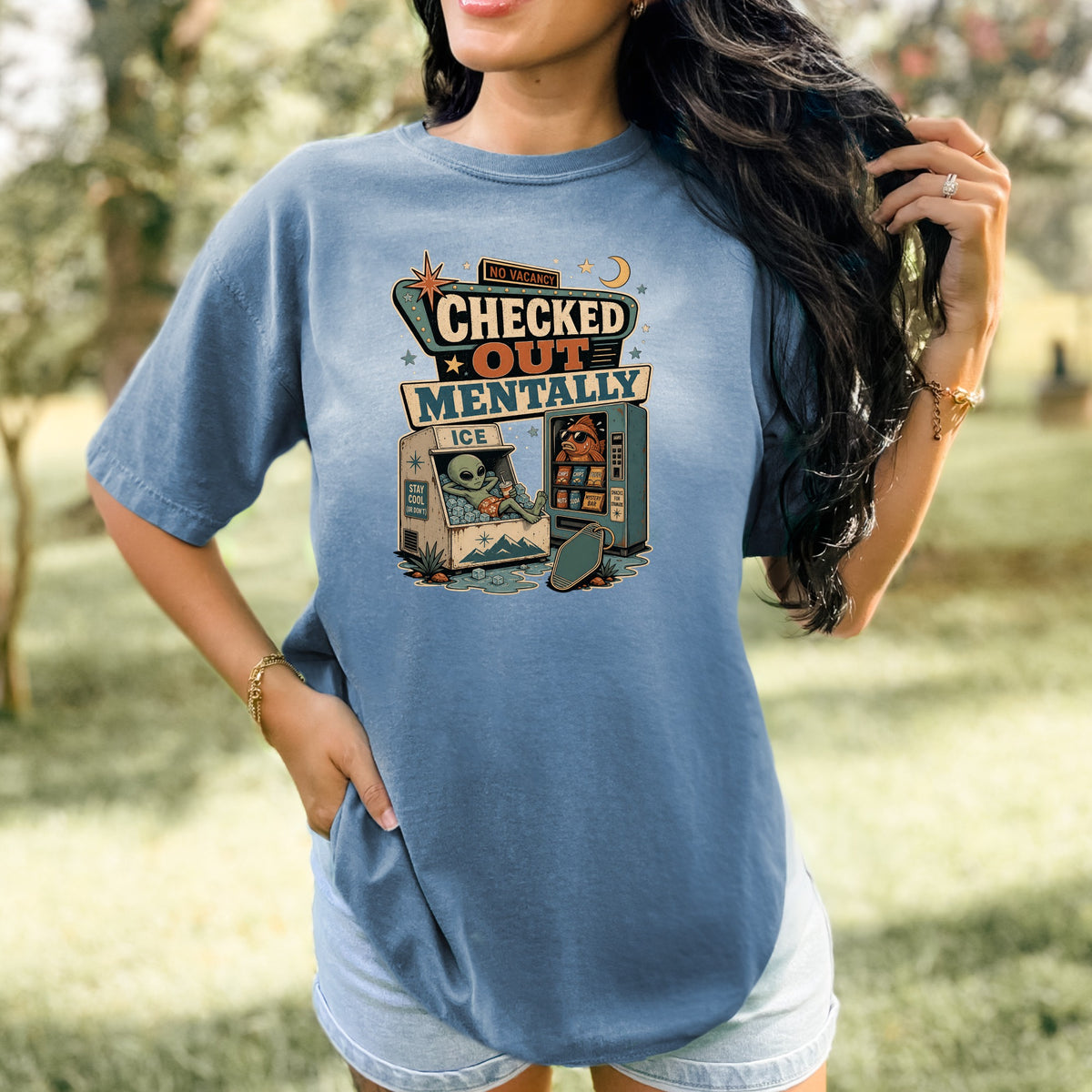 Graphic tee with alien and fish at a vending machine, reading "Checked Out Mentally."
