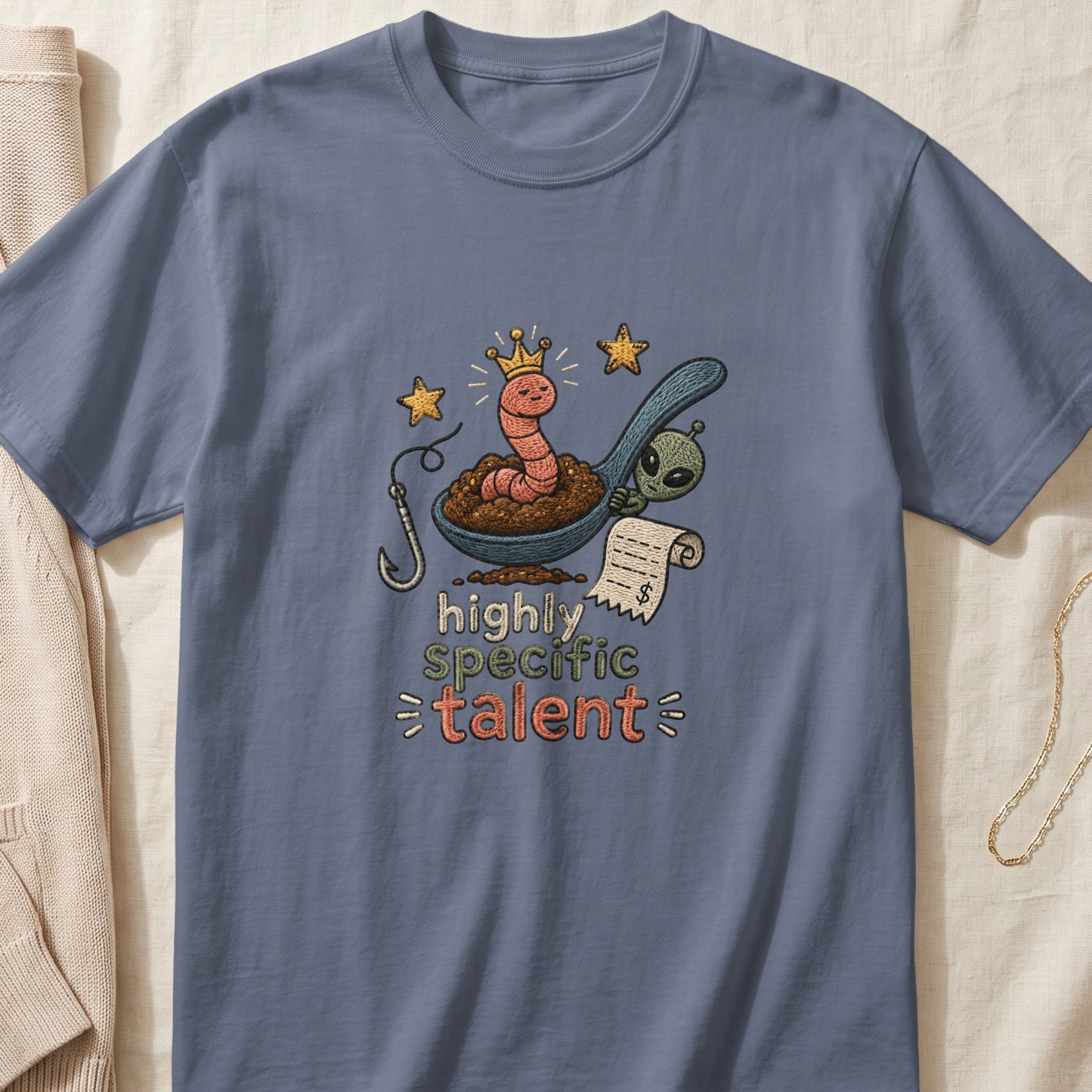 T-shirt graphic with worm, alien, fishing hook, and text: "highly specific talent".