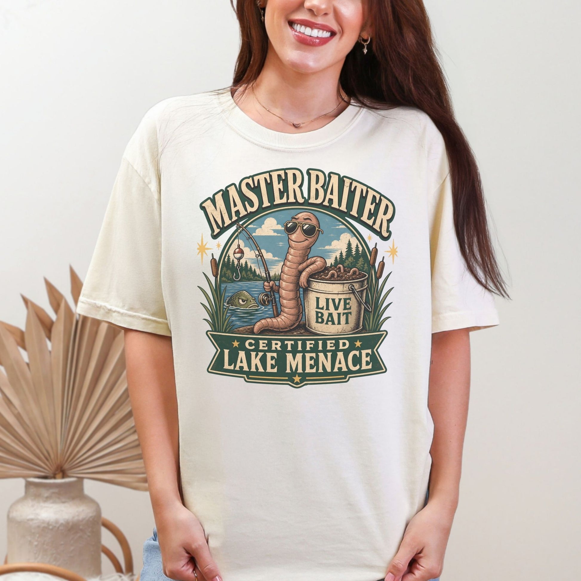 T-shirt graphic with text "Masterbaiter Certified Lake Menace" and a worm with sunglasses fishing.