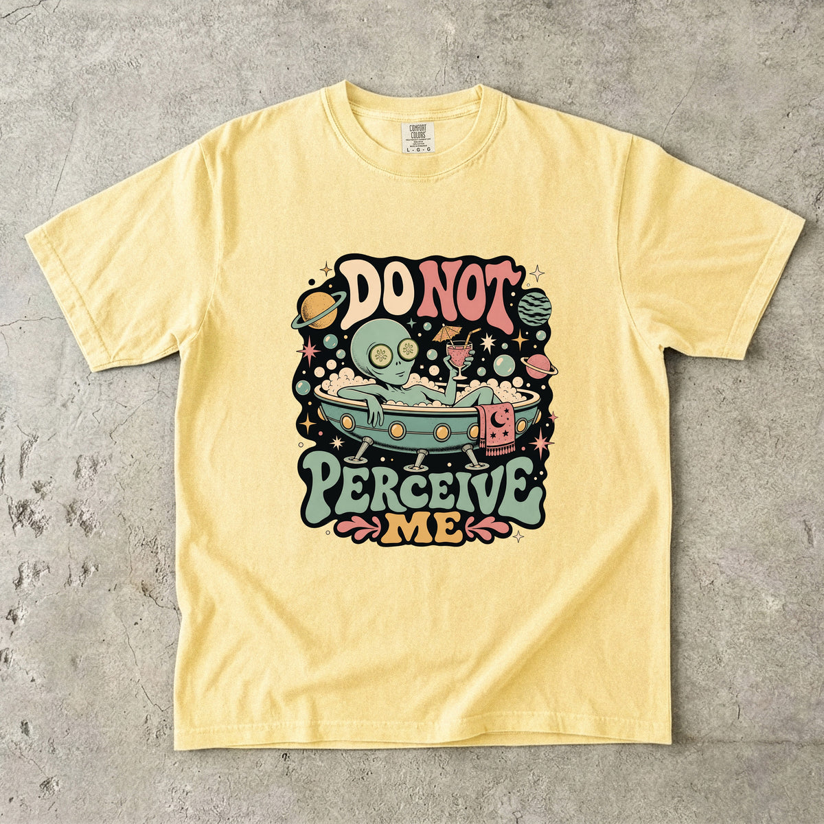 Yellow t-shirt with graphic of alien in bathtub saying "DO NOT PERCEIVE ME".
