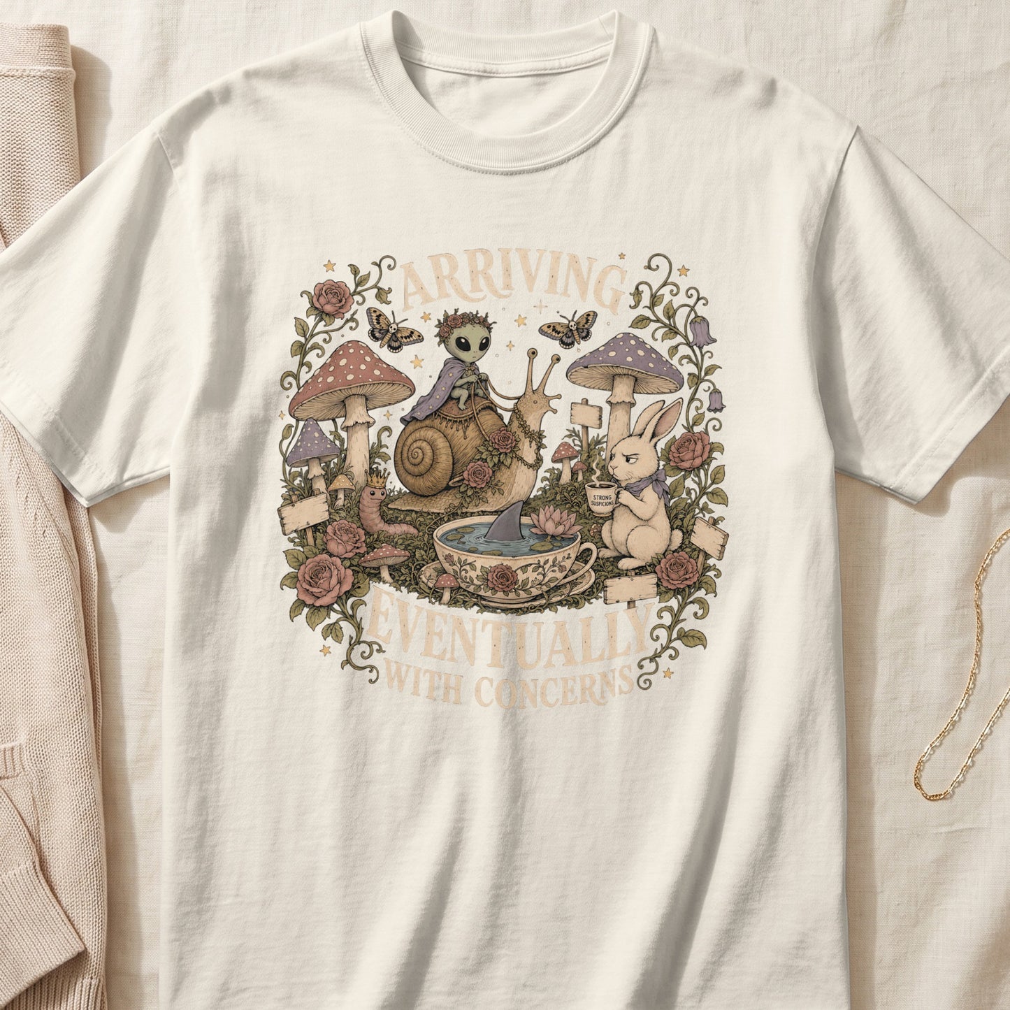 T-shirt with whimsical art of alien, snail, bunny, and shark in a teacup with text.