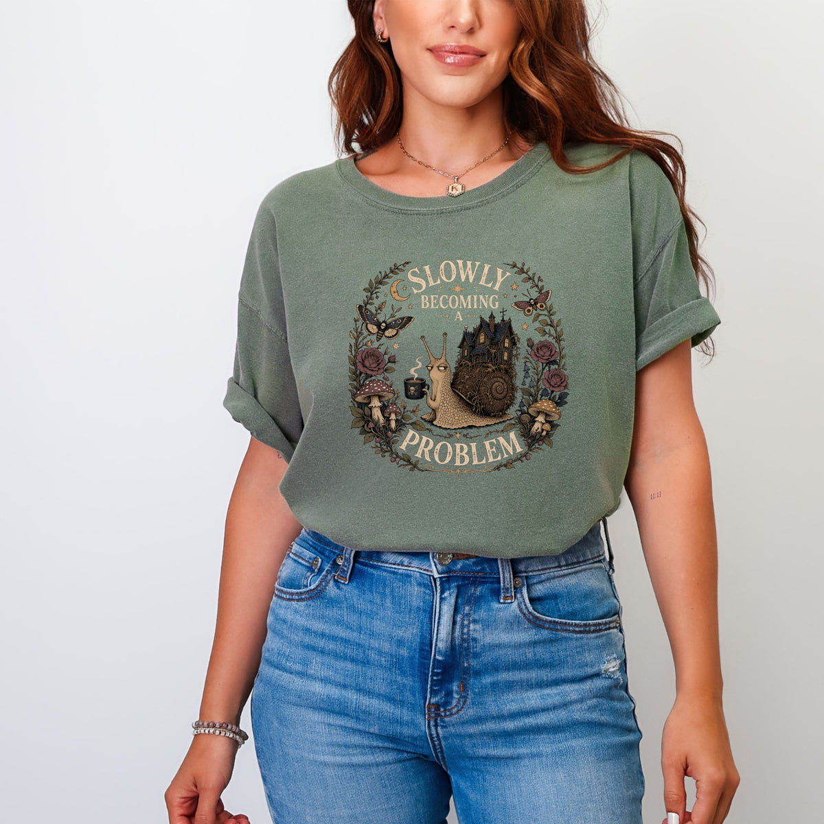 Green t-shirt with a circular graphic featuring a snail, castle, and text "Slowly Becoming A Problem".