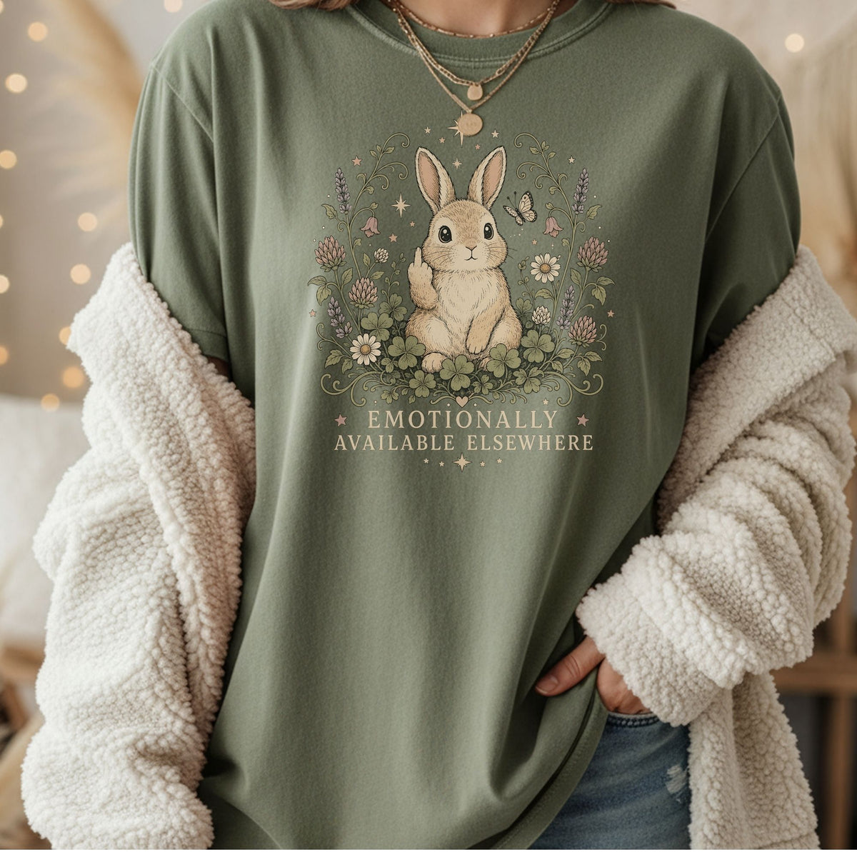 Green t-shirt with a bunny and flowers graphic saying "Emotionally Available Elsewhere".