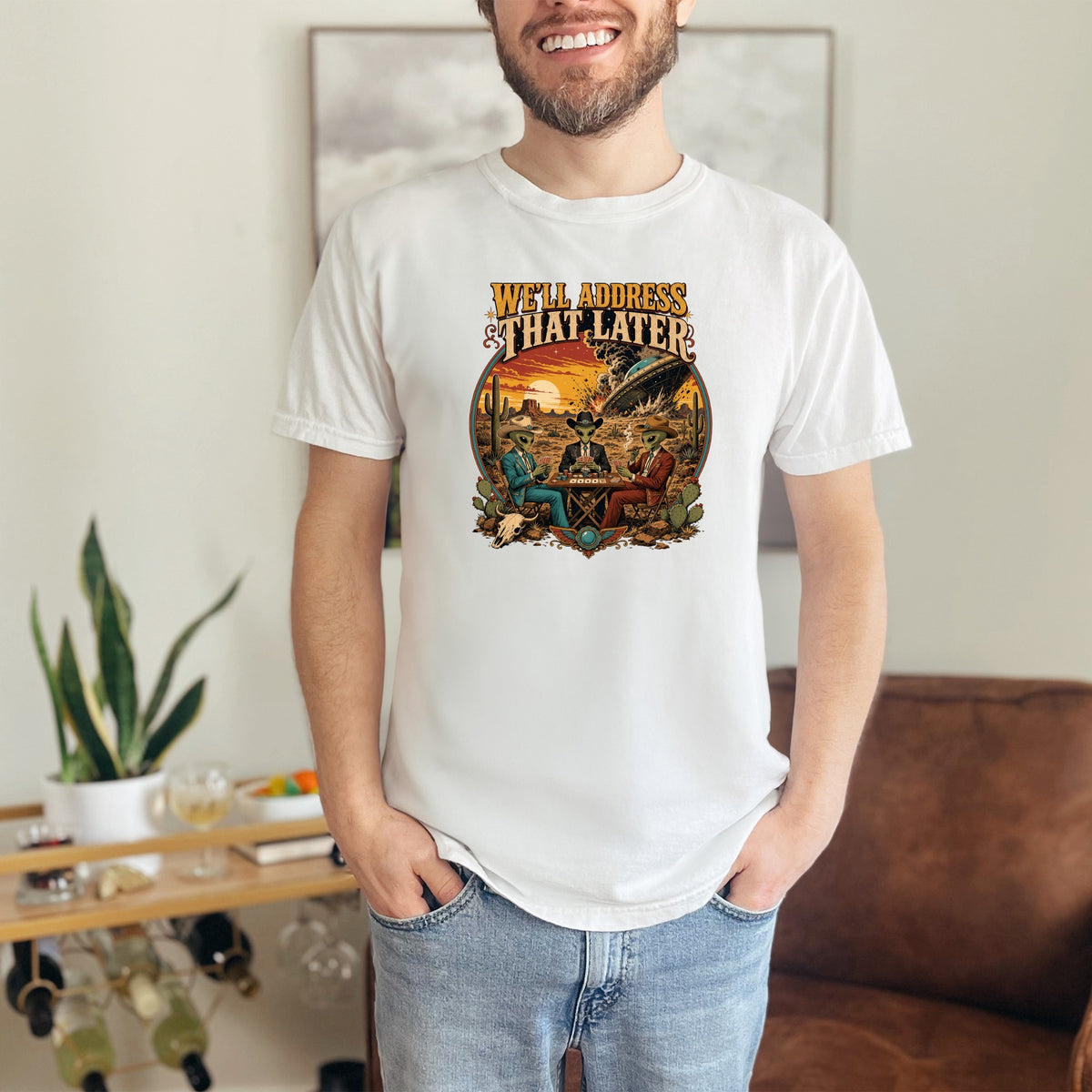 T-shirt graphic: "We'll address that later" text with aliens playing poker during a UFO crash.