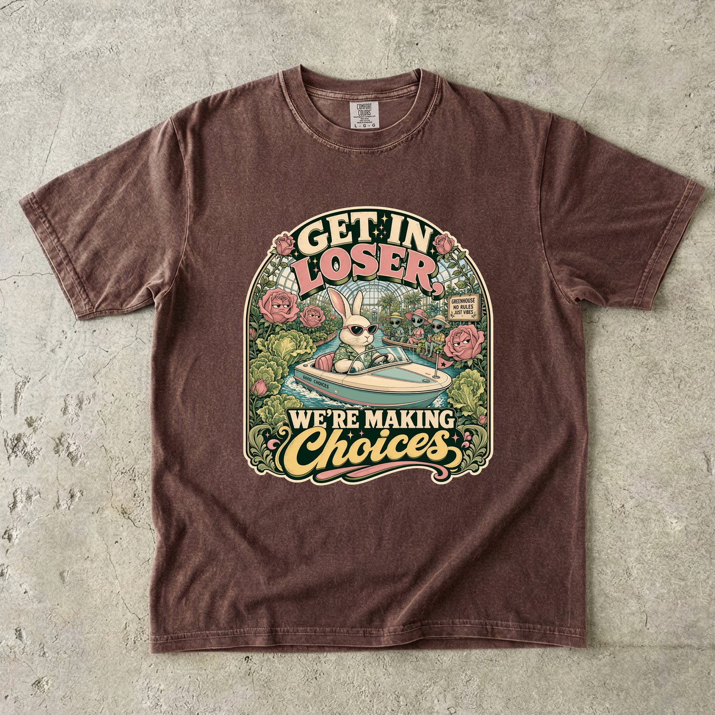 Brown t-shirt with graphic of a rabbit in a boat with aliens, saying "GET IN LOSER, WE'RE MAKING Choices".