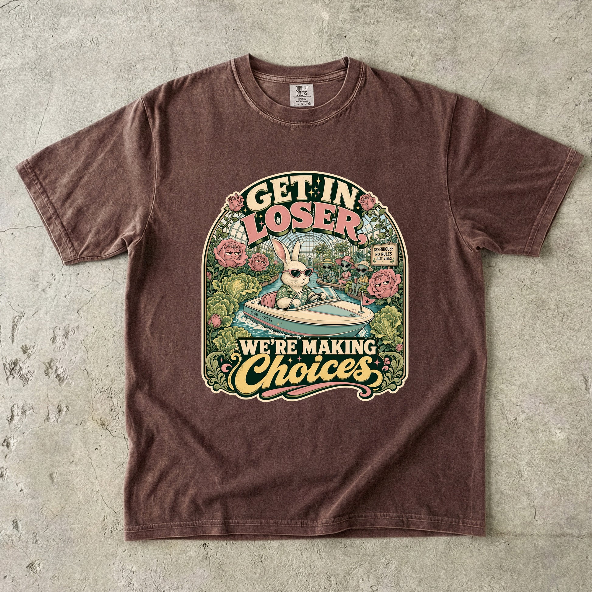 Brown t-shirt with graphic of a rabbit in a boat with aliens, saying "GET IN LOSER, WE'RE MAKING Choices".