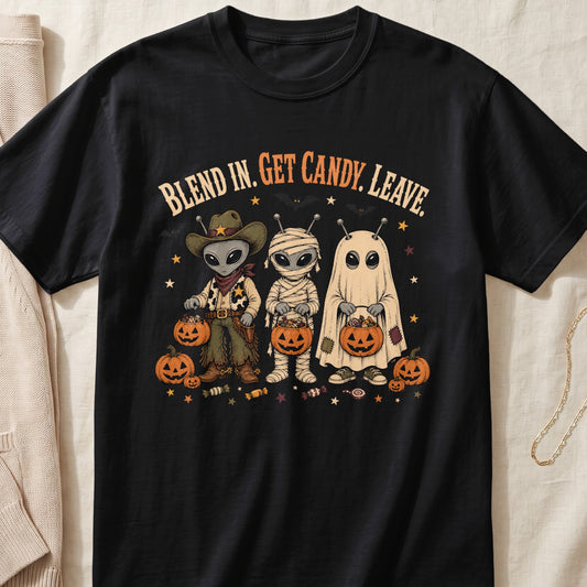 Black t-shirt with aliens dressed as a cowboy, mummy, and ghost holding candy pumpkins.