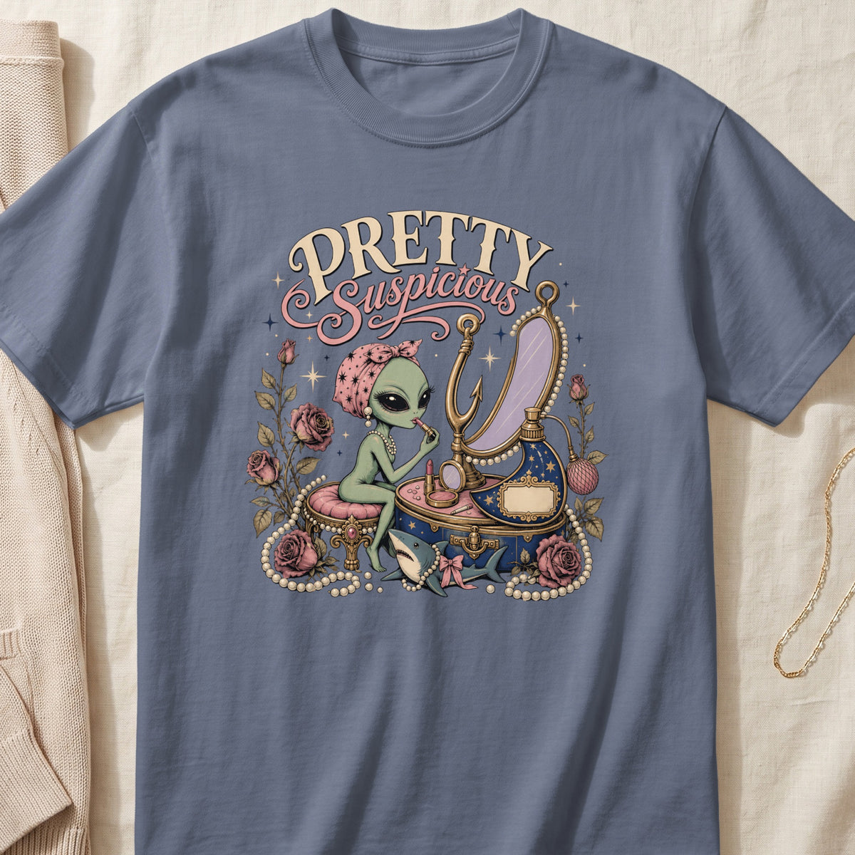 Alien with lipstick and shark on t-shirt with "PRETTY Suspicious" text.