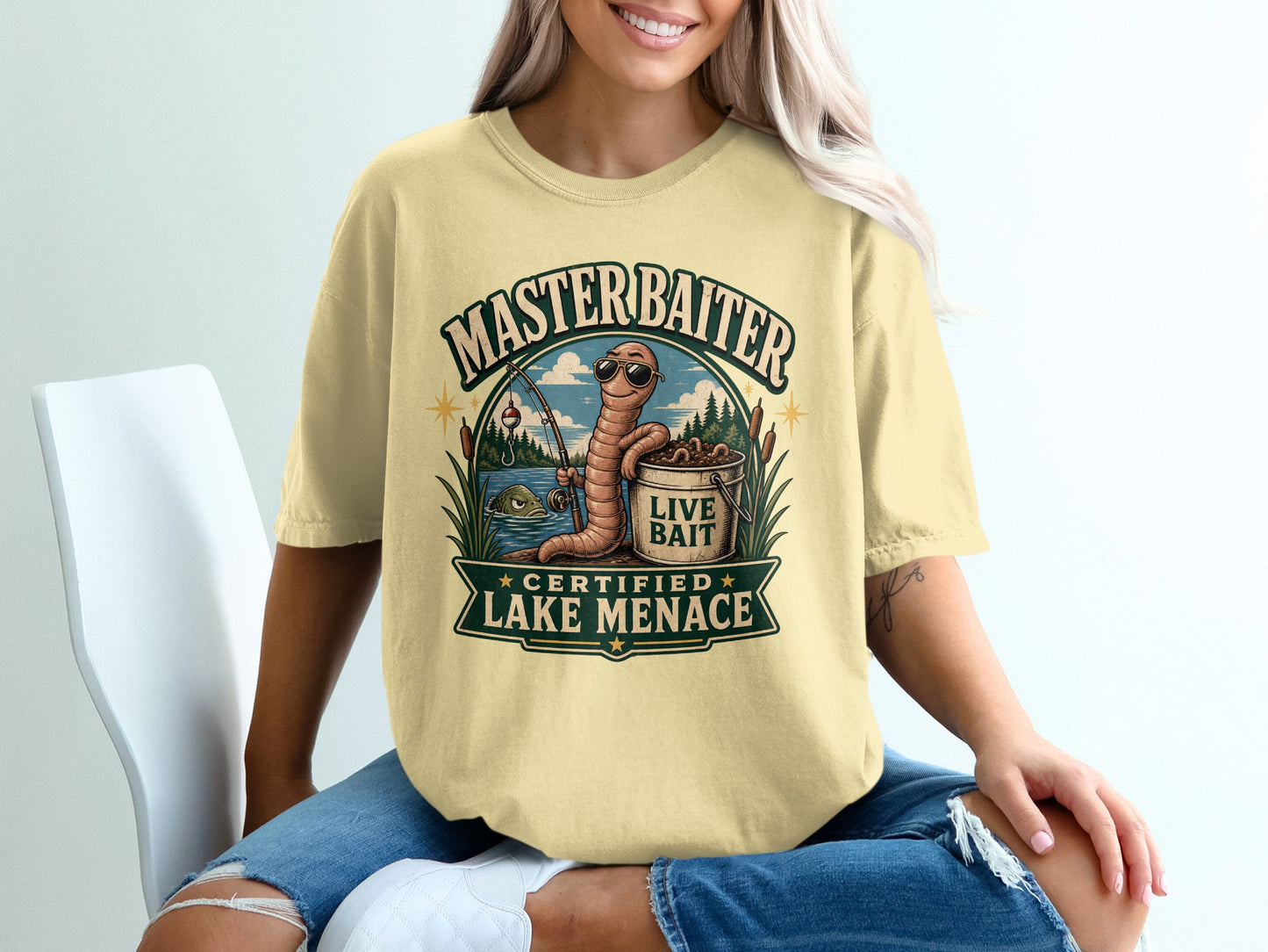 T-shirt graphic with a worm wearing sunglasses, holding a fishing rod, with text: MASTERBAITER CERTIFIED LAKE MENACE.