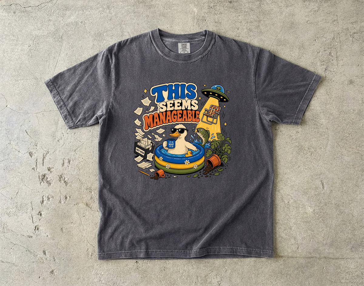 T-shirt graphic of a duck in a pool with text "THIS SEEMS MANAGEABLE".