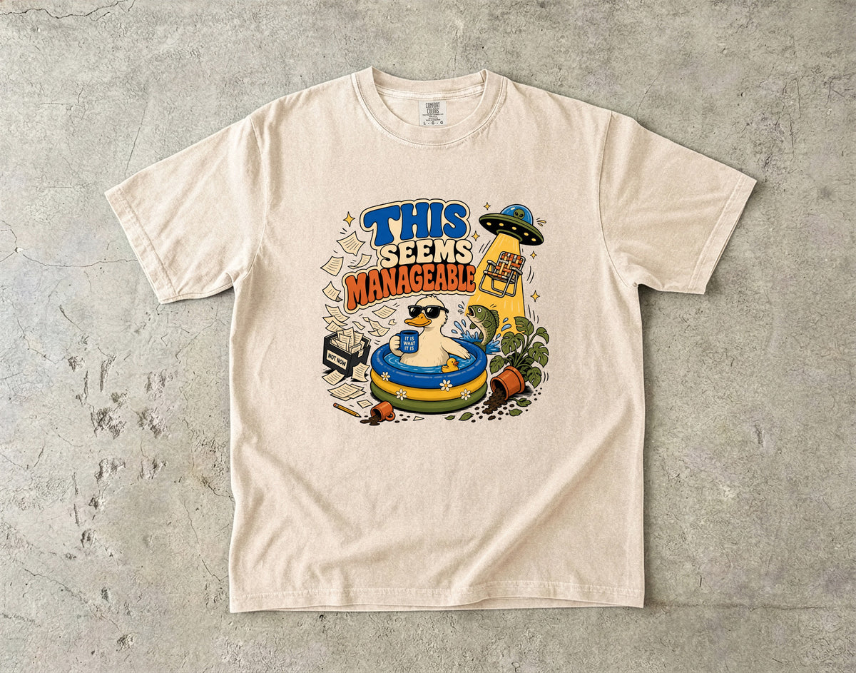 T-shirt graphic of a duck in a pool with text "THIS SEEMS MANAGEABLE".