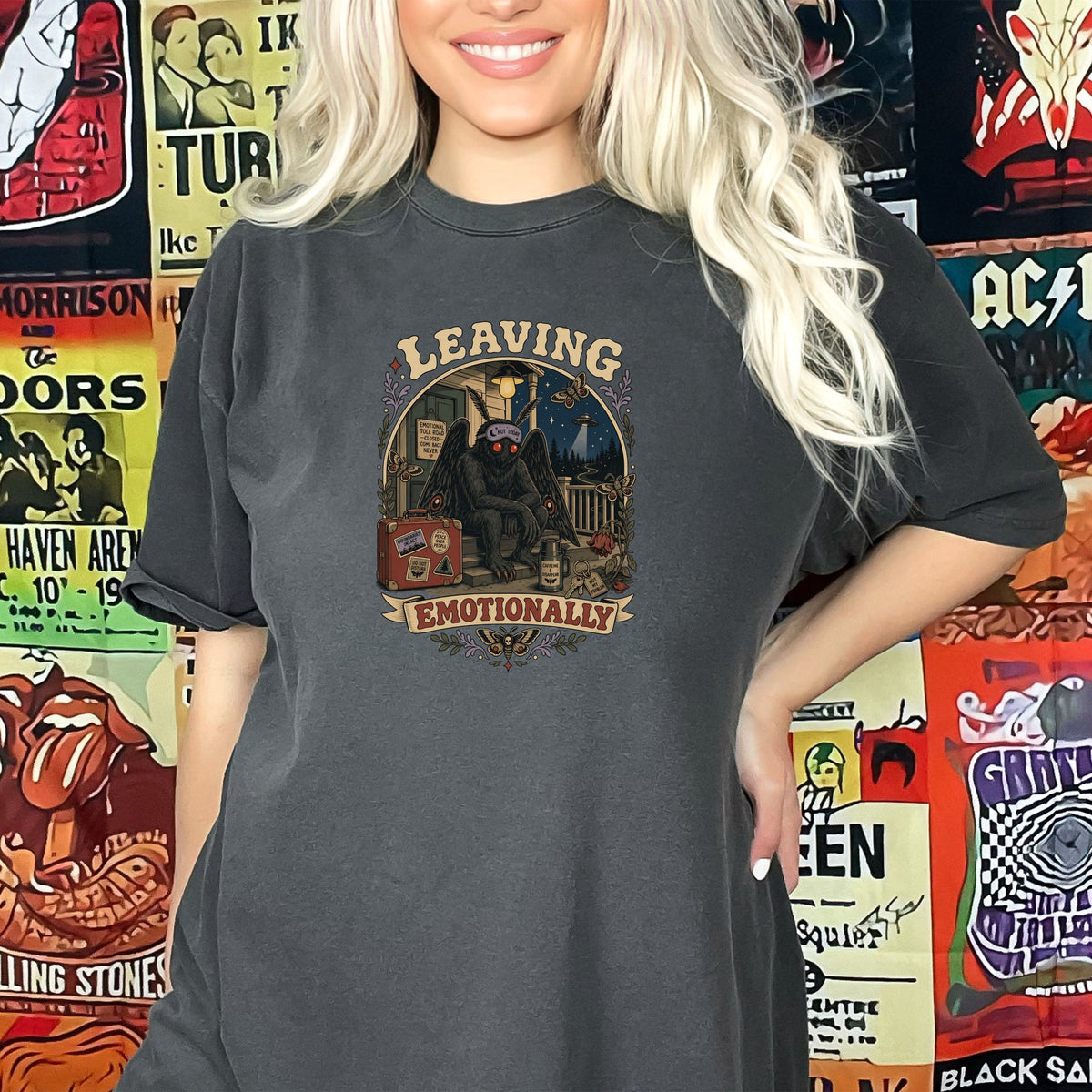 Dark t-shirt with "Leaving Emotionally" graphic featuring a mothman and suitcase.