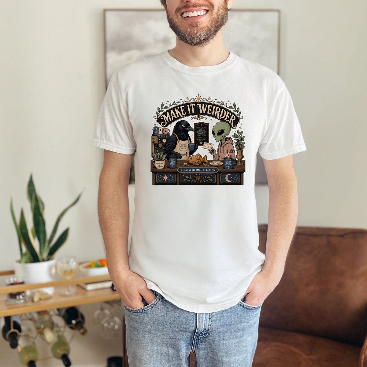 White t-shirt with "Make it weirder" text, crow, alien, and fish.