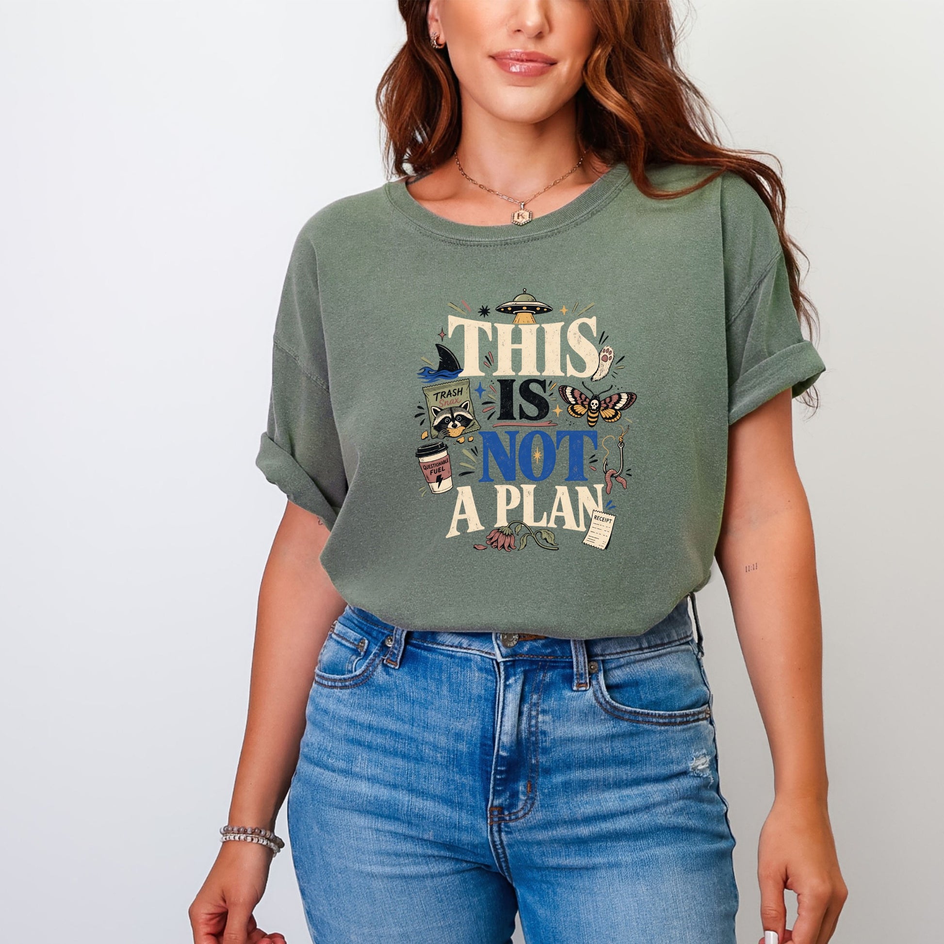Green t-shirt with "THIS IS NOT A PLAN" graphic and assorted whimsical elements.