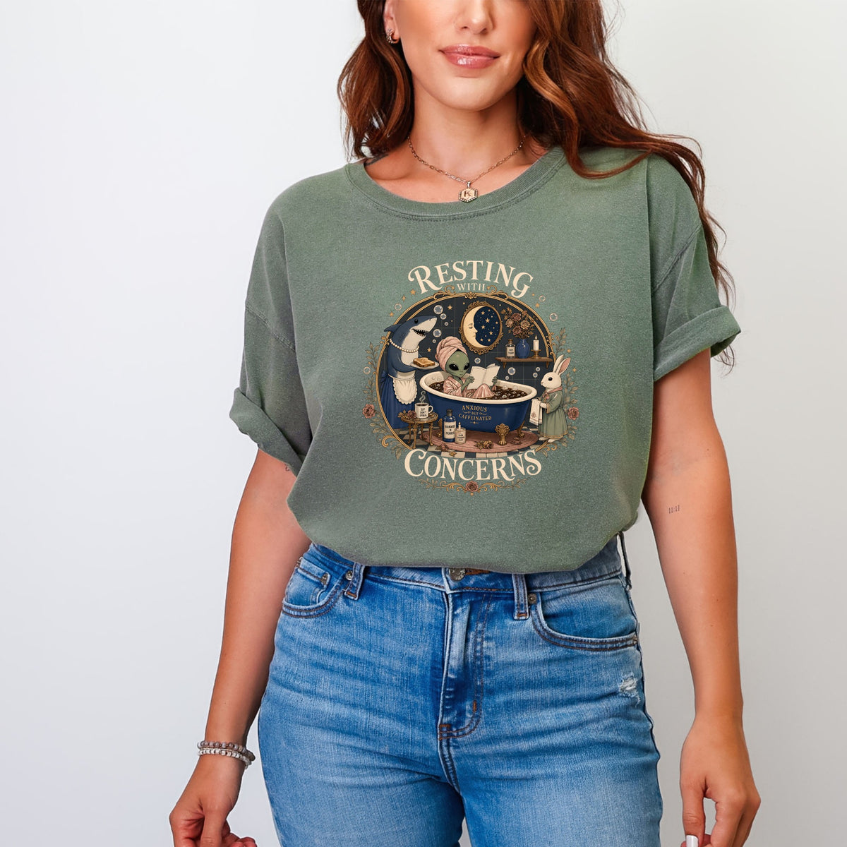 Green t-shirt with circular graphic of alien in bath, shark, and rabbit, text "Resting with Anxious Concerns".