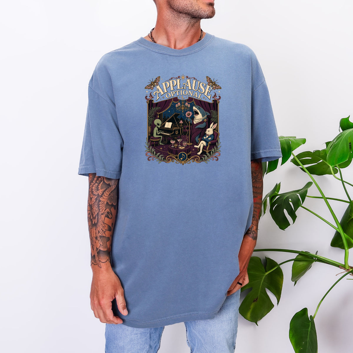 T-shirt with "APPLAUSE OPTIONAL" graphic featuring an alien, shark, and rabbit in a surreal performance scene.