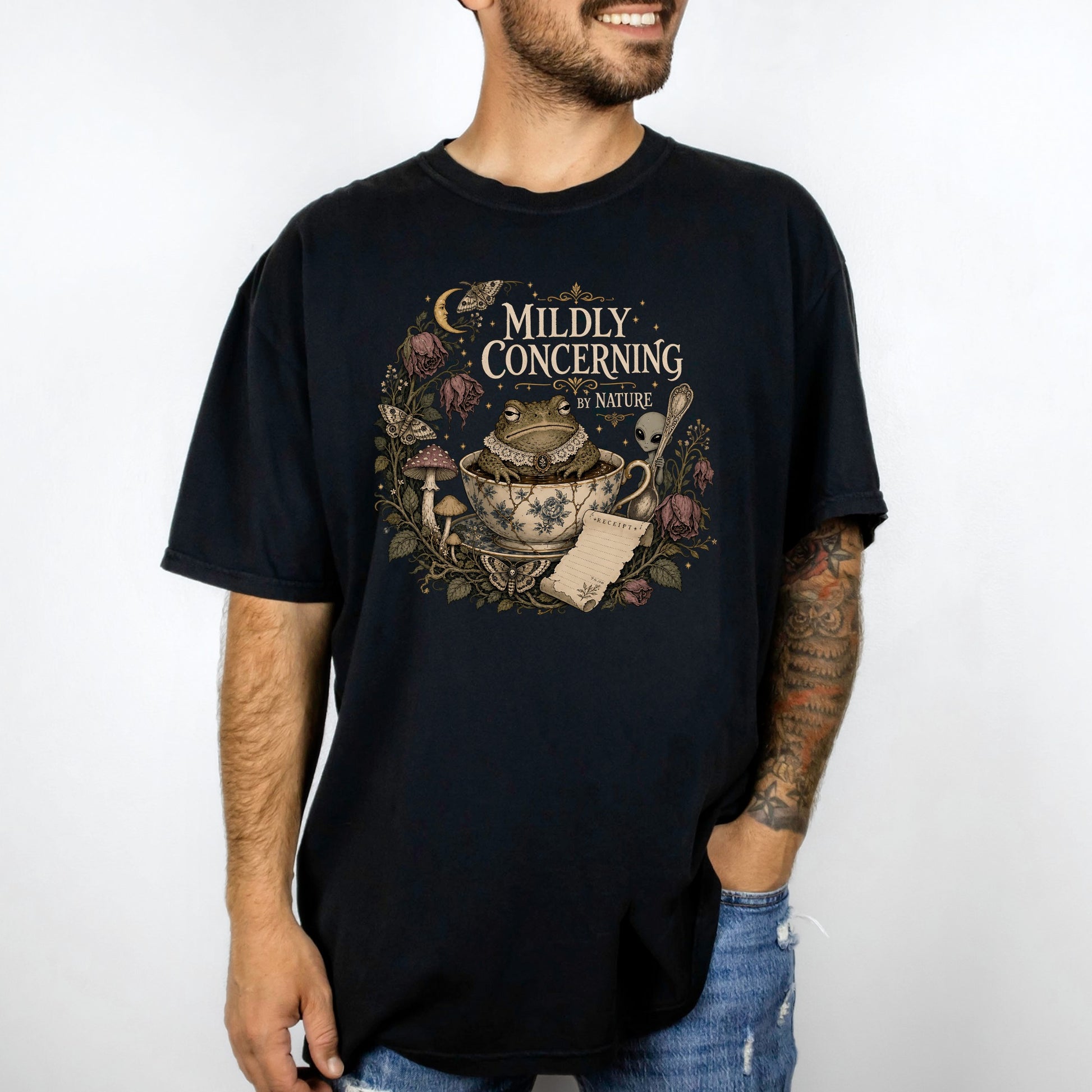 Black t-shirt with a "Mildly Concerning by Nature" graphic featuring a frog in a teacup.