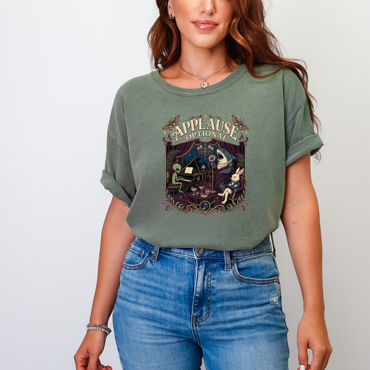 Green t-shirt with "Applause Optional" text and a surreal scene of a shark singing, alien at piano, and rabbit.