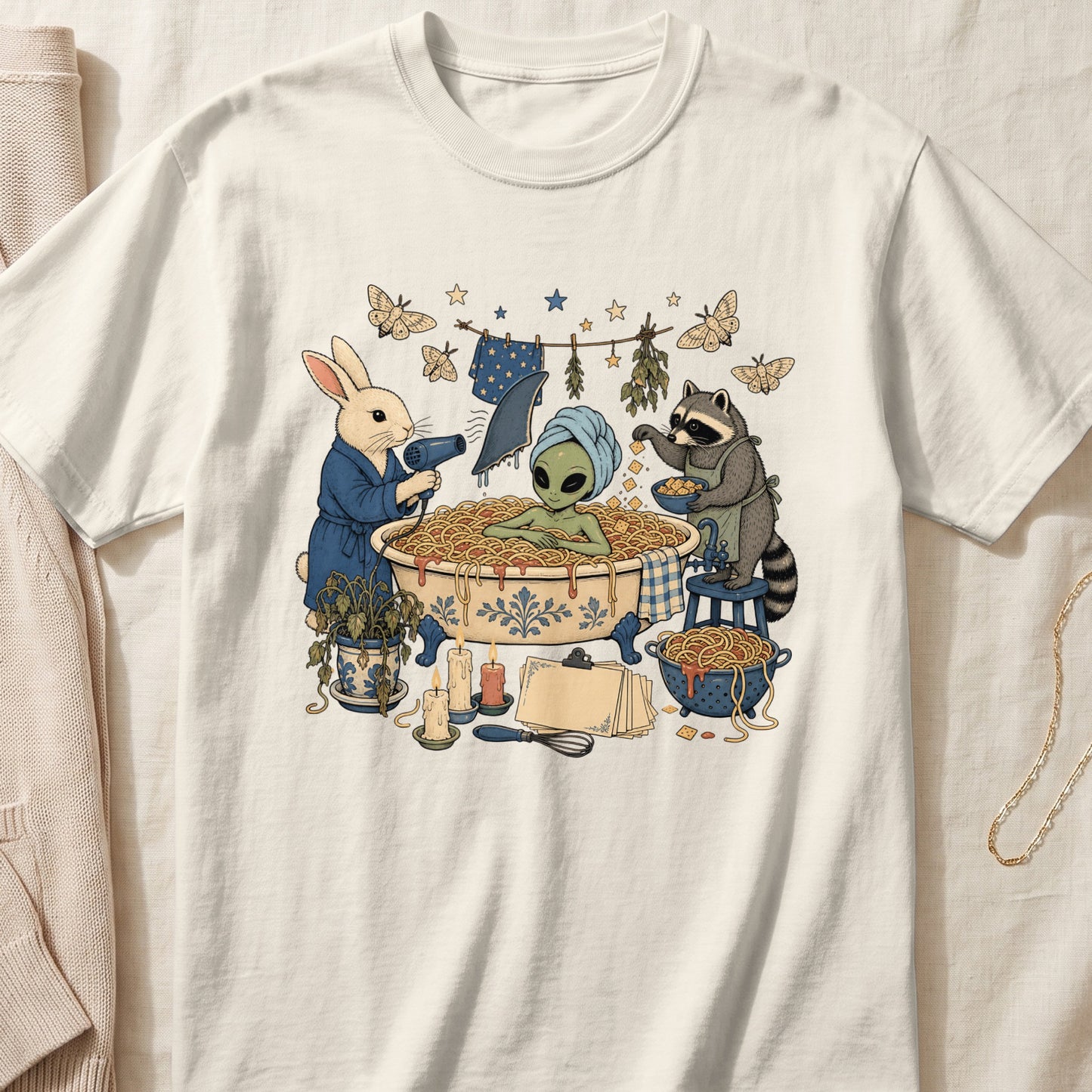Off-white crewneck t-shirt featuring a vintage-style graphic of an alien bathing in spaghetti, assisted by a rabbit and a raccoon.