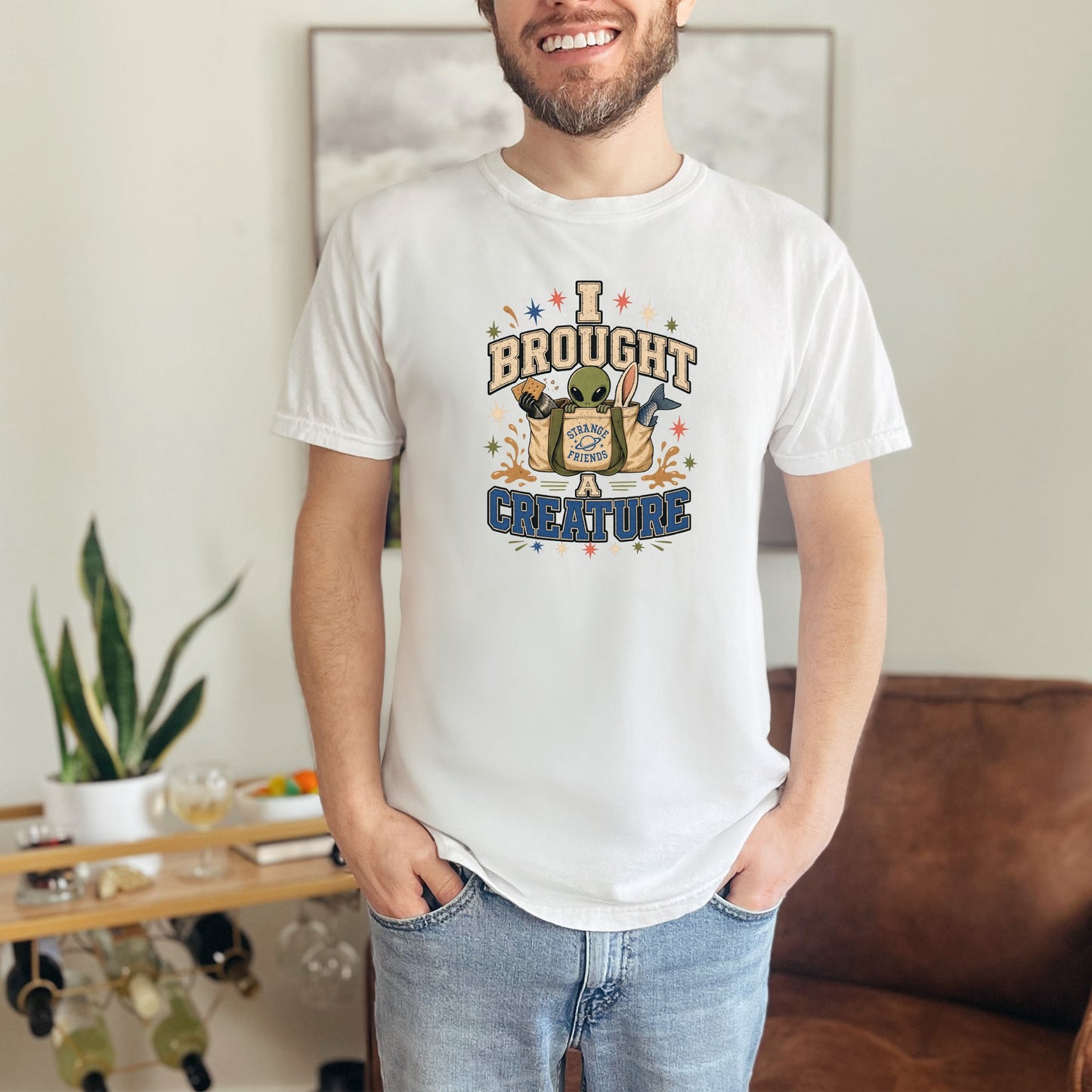 White t-shirt with graphic saying "I Brought Strange Friends A Creature" with alien.