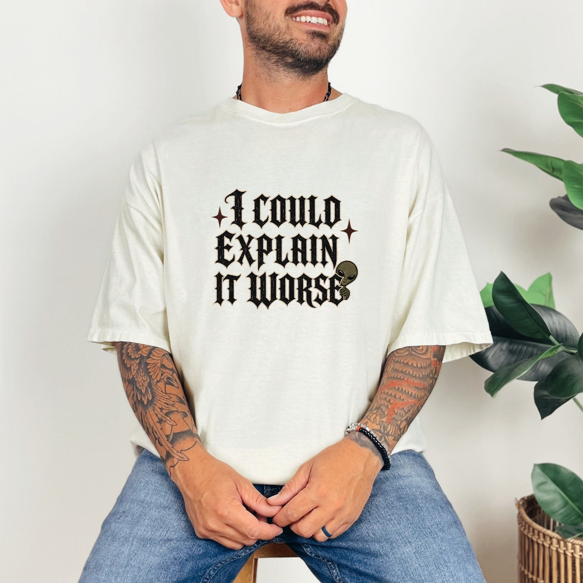 Cream t-shirt with "I COULD EXPLAIN IT WORSE" text and an alien graphic.